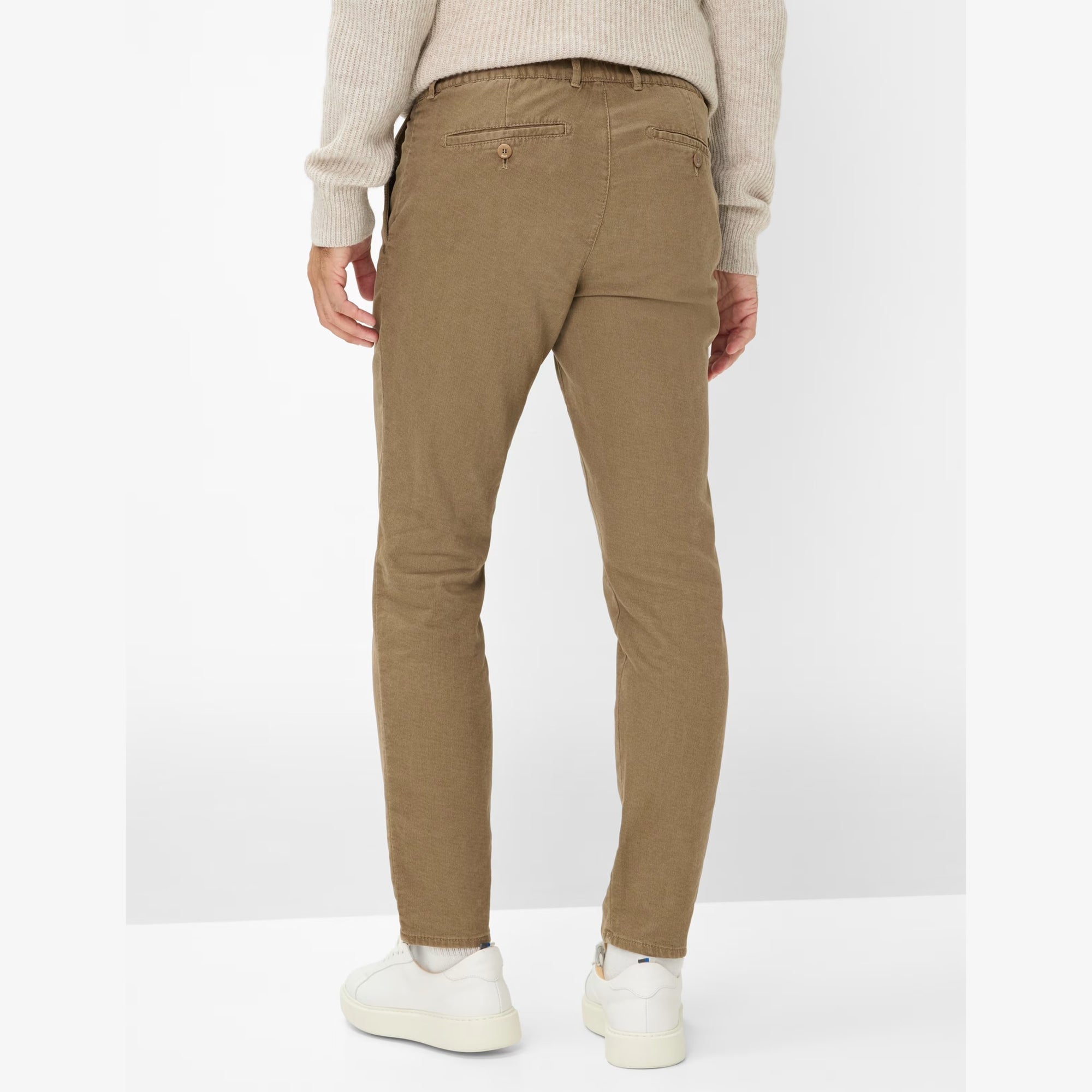 Person wearing beige pants on a white background