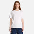 A woman wearing a Timberland plain white short-sleeve crewneck t-shirt and dark blue jeans, standing against a light gray studio background.