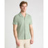 Man wearing a light green short-sleeve shirt on a white background