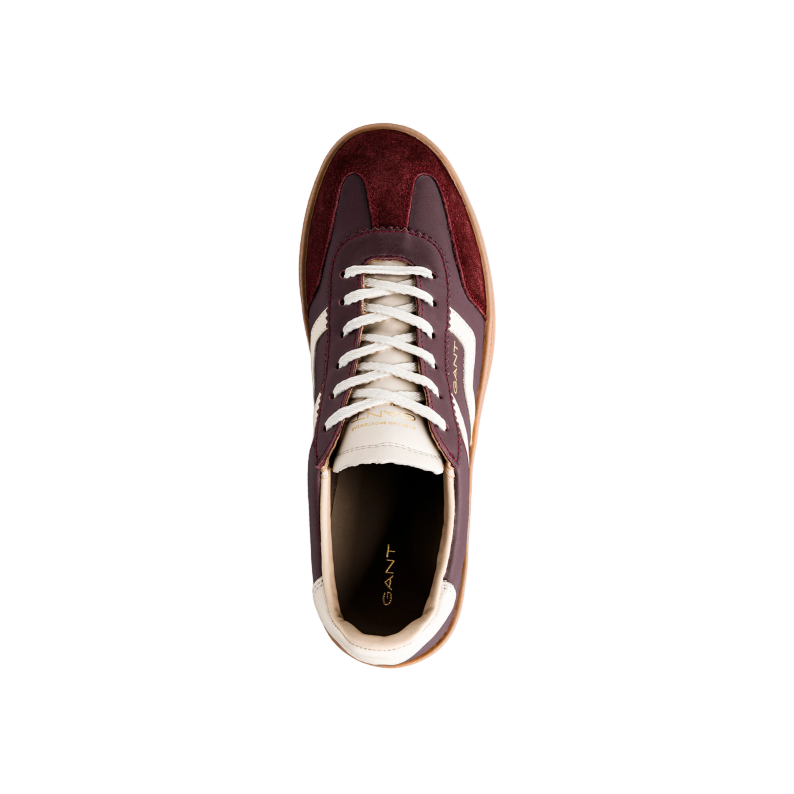 Maroon sneaker with white laces on a light gray background
