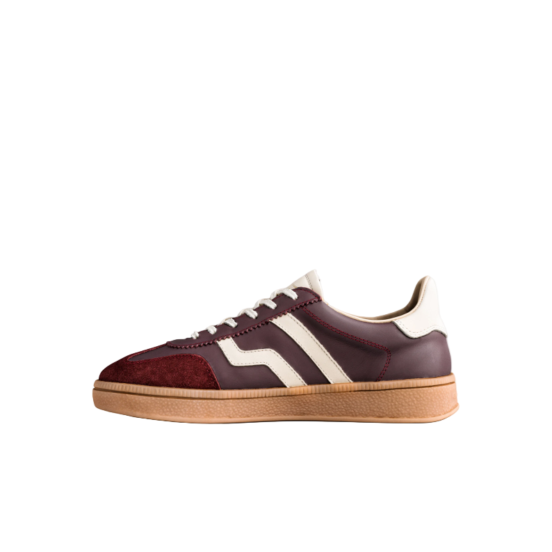 Maroon sneaker with white stripes on a light gray background