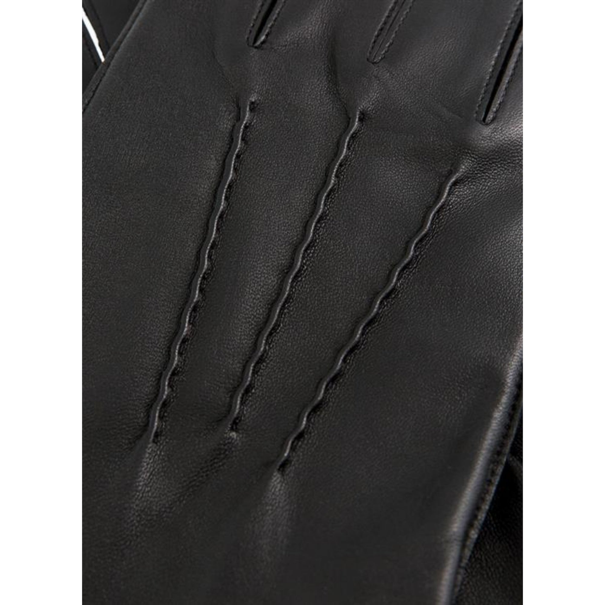 Close-up of a black leather glove with stitching details on a white background