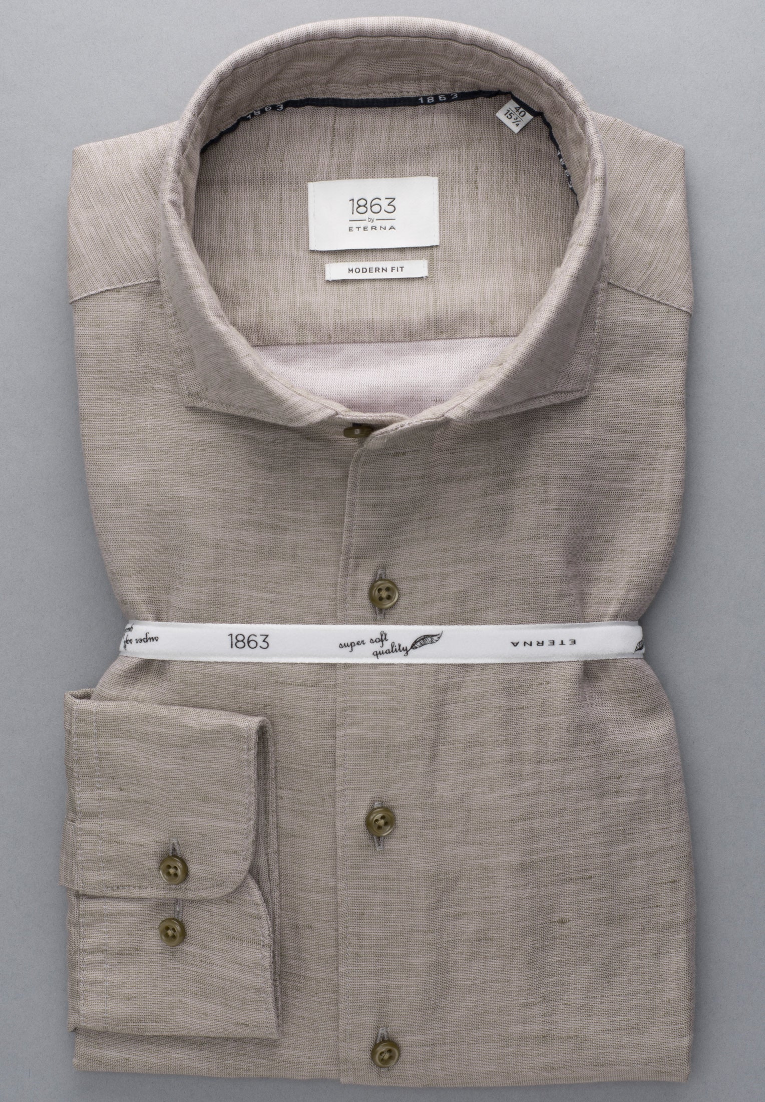 Folded beige shirt with visible brand label on a gray background