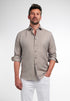 Man wearing a light brown button-up shirt and white pants on a plain background