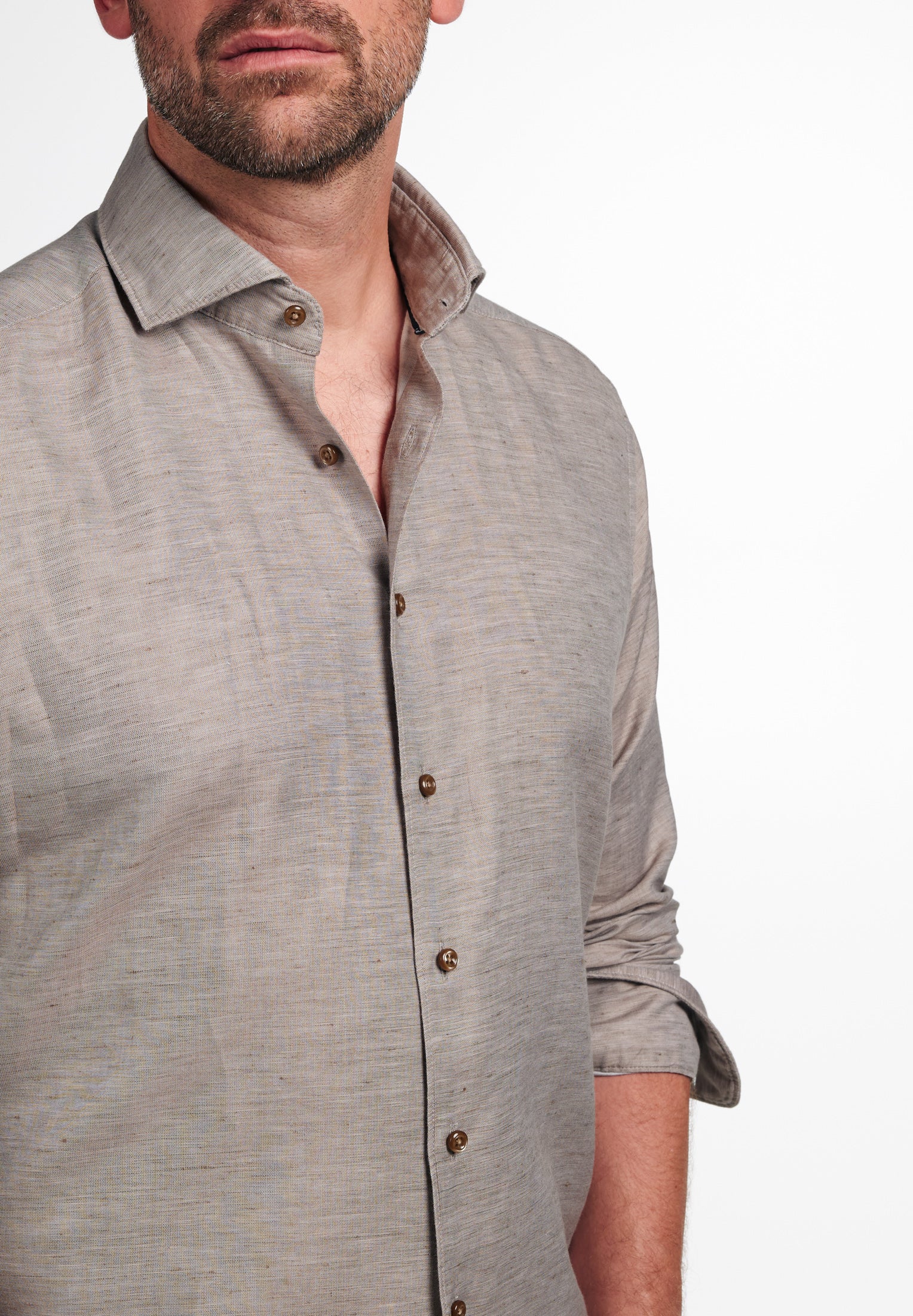 Man wearing a light gray button-up shirt on a white background