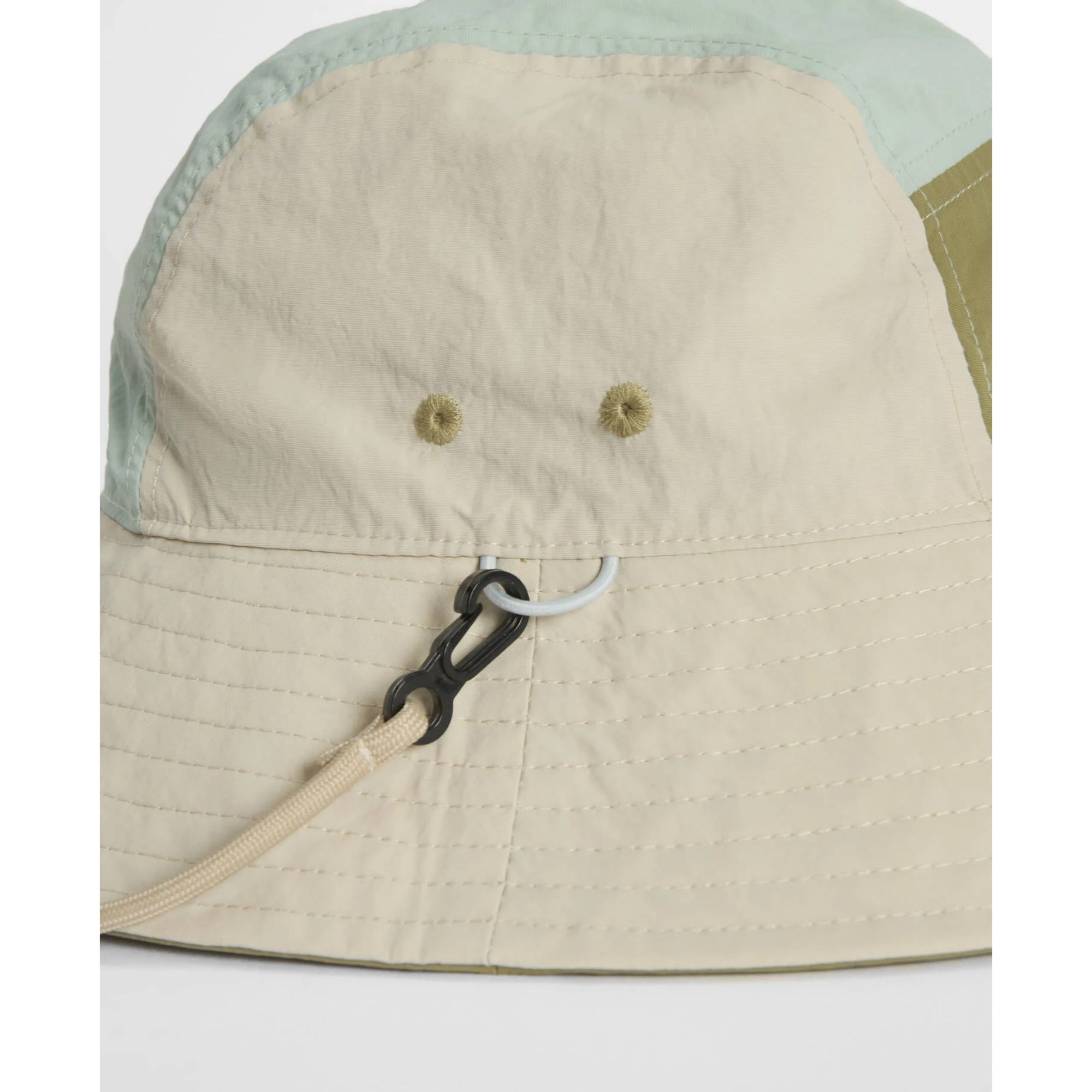 Close-up of a bucket hat with a beige brim and green top on a white background