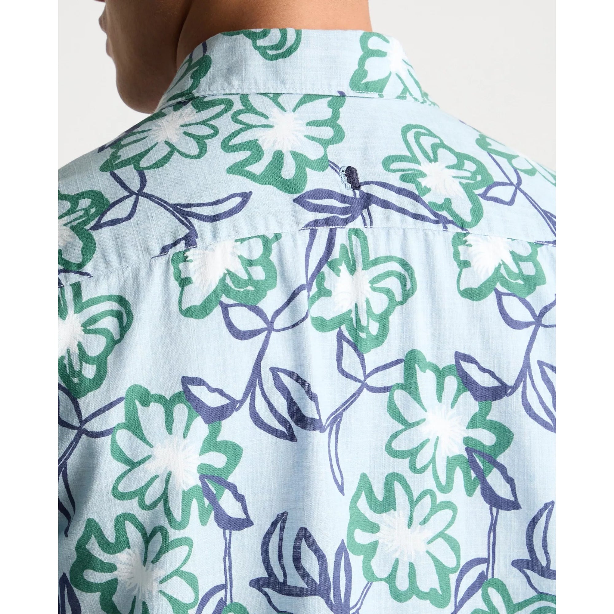 Close-up of a light blue shirt with green and purple floral pattern