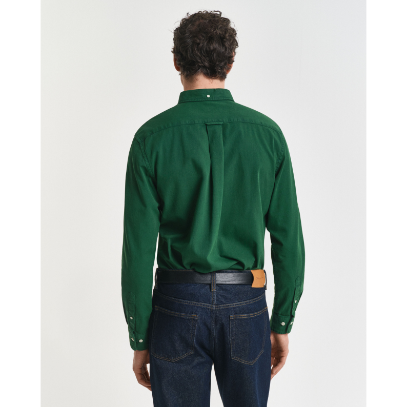 Person wearing a GANT green shirt and blue jeans from behind on a white background