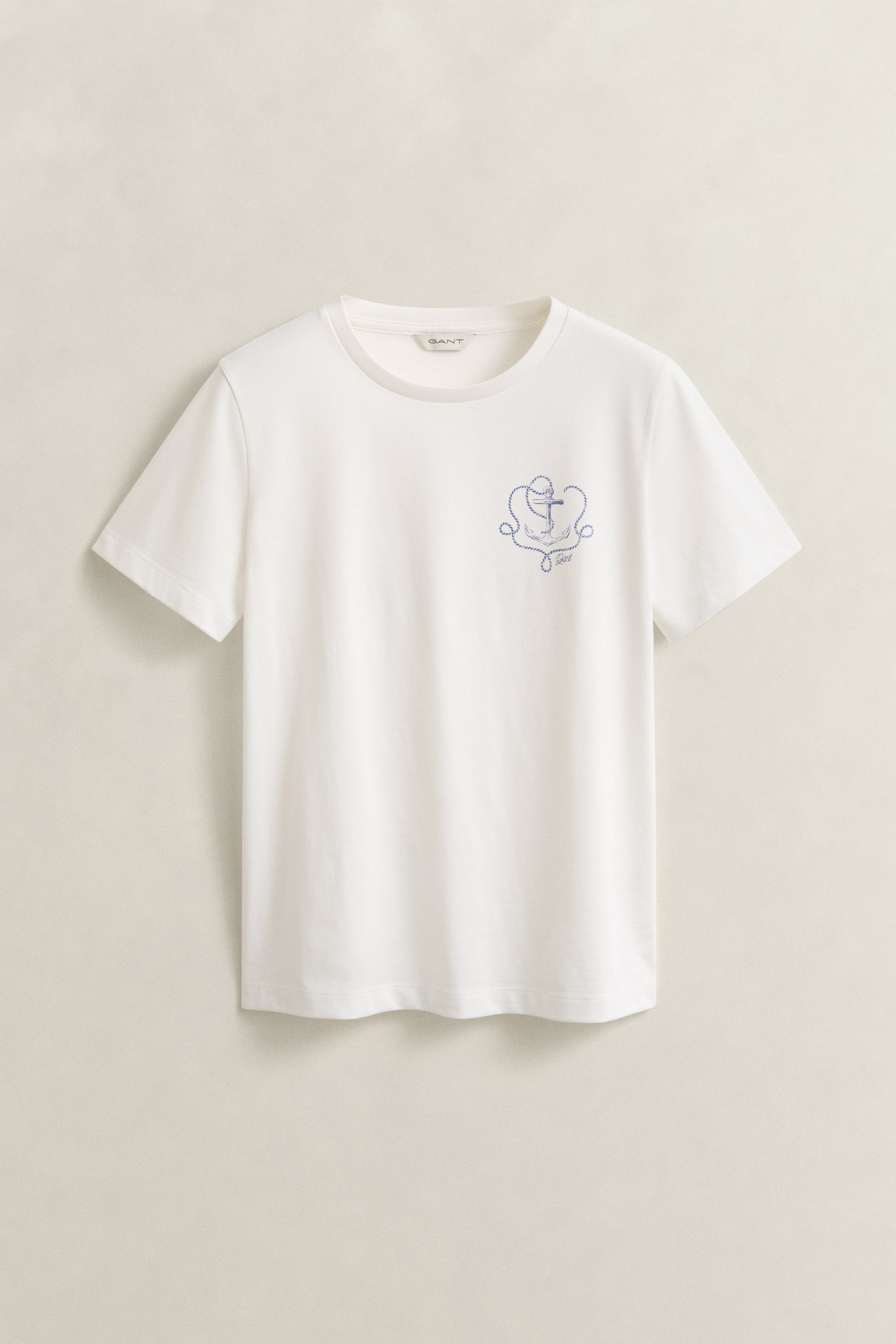 White t-shirt with a small embroidered design on a beige background