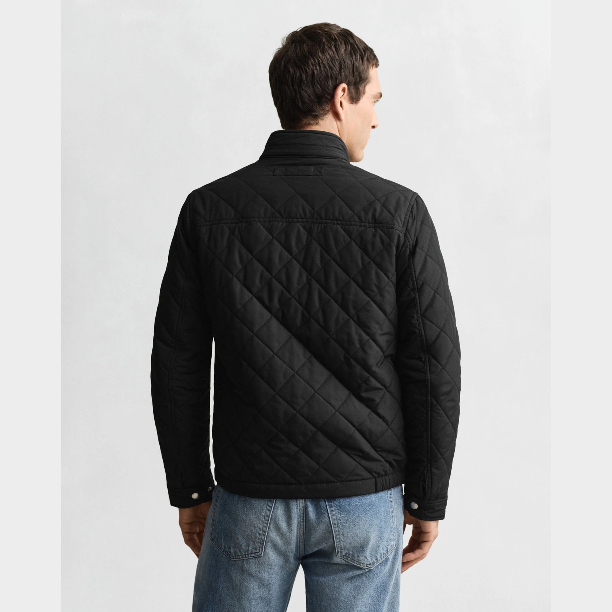 GANT Quilted Windcheater in Black. Diamond quilting, recycled polyester padding, water-repellent finish, snap buttons, slanted pockets – versatile transitional layer. 
ack