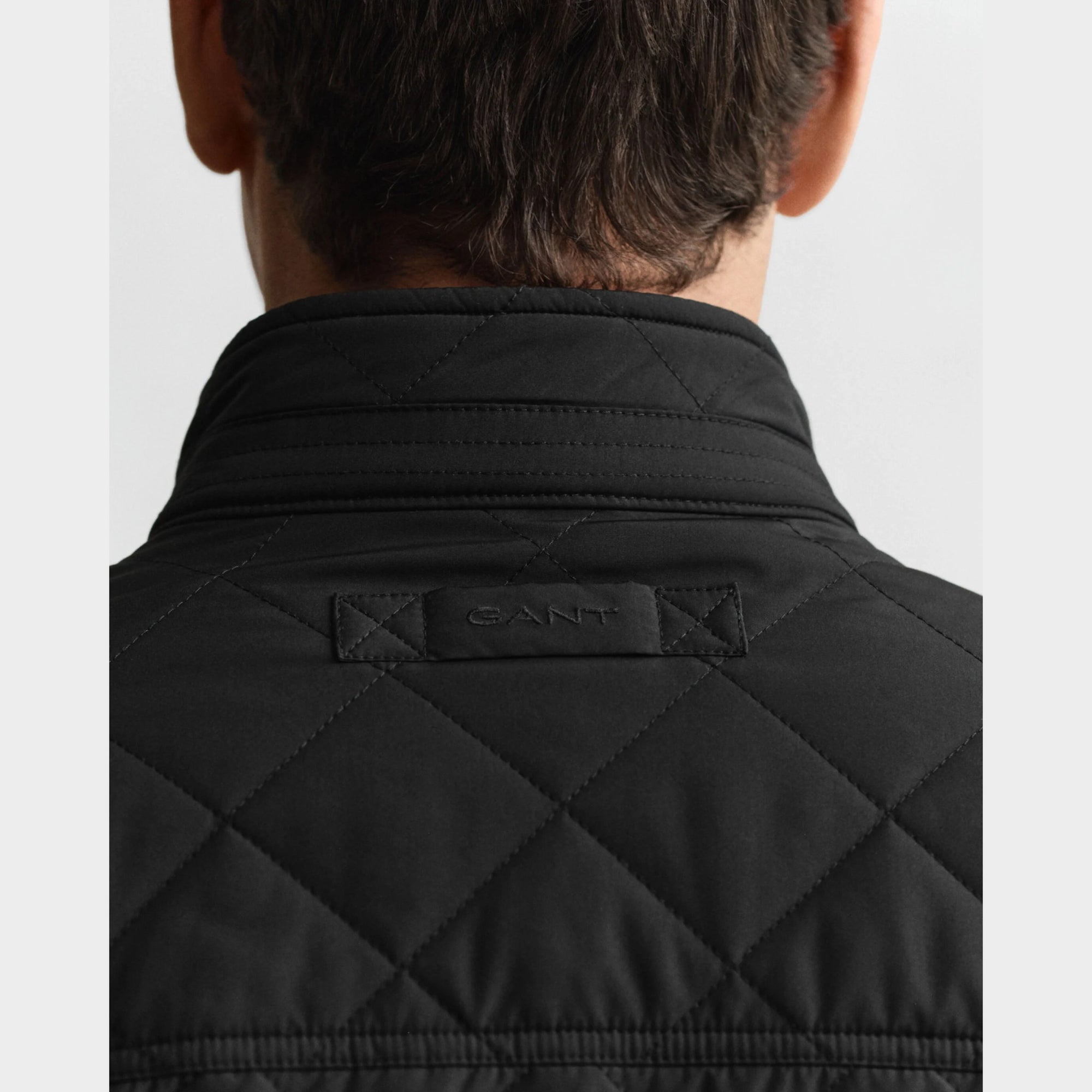 GANT Quilted Windcheater in Black. Diamond quilting, recycled polyester padding, water-repellent finish, snap buttons, slanted pockets – versatile transitional layer.
