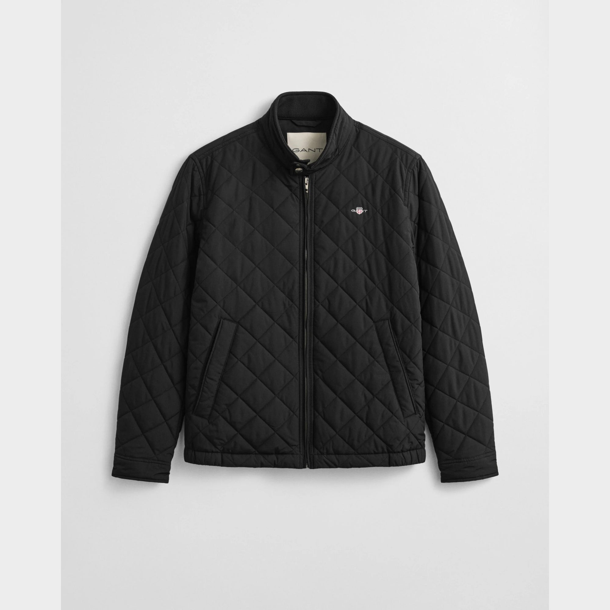GANT Quilted Windcheater in Black. Diamond quilting, recycled polyester padding, water-repellent finish, snap buttons, slanted pockets – versatile transitional layer.
