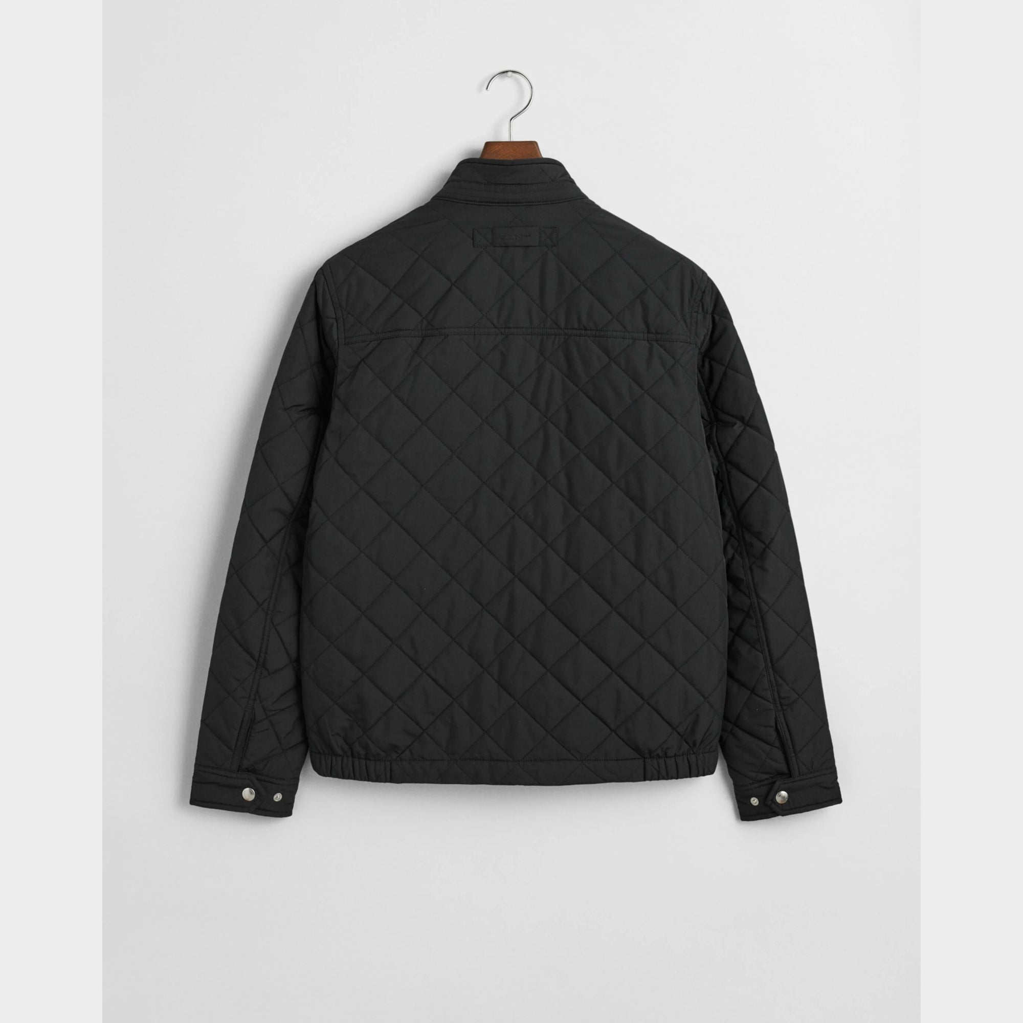 GANT Quilted Windcheater in Black. Diamond quilting, recycled polyester padding, water-repellent finish, snap buttons, slanted pockets – versatile transitional layer.
