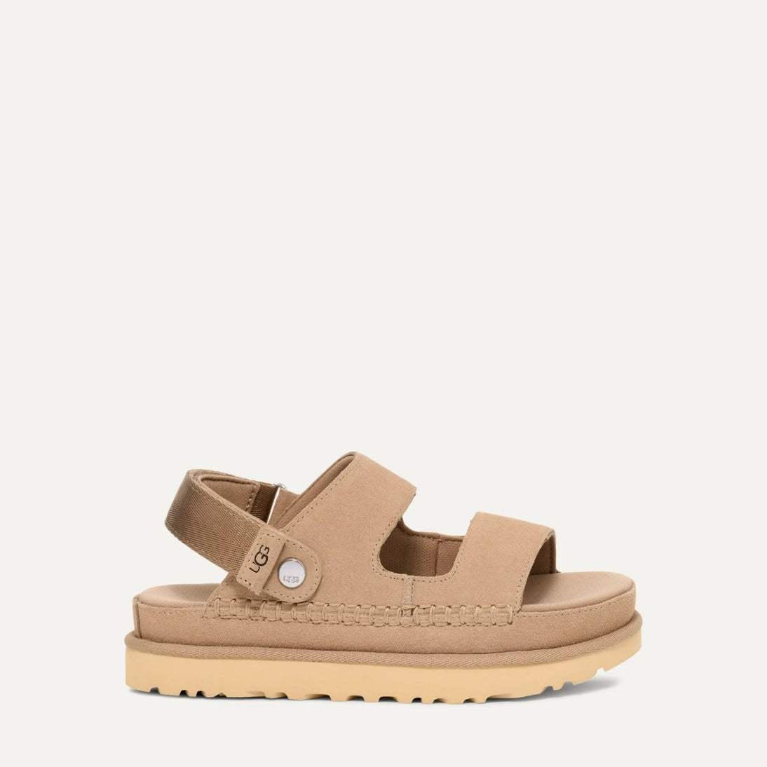 A pair of UGG Goldenstar Glide sandals in sand color with an adjustable heel strap and a low heel.