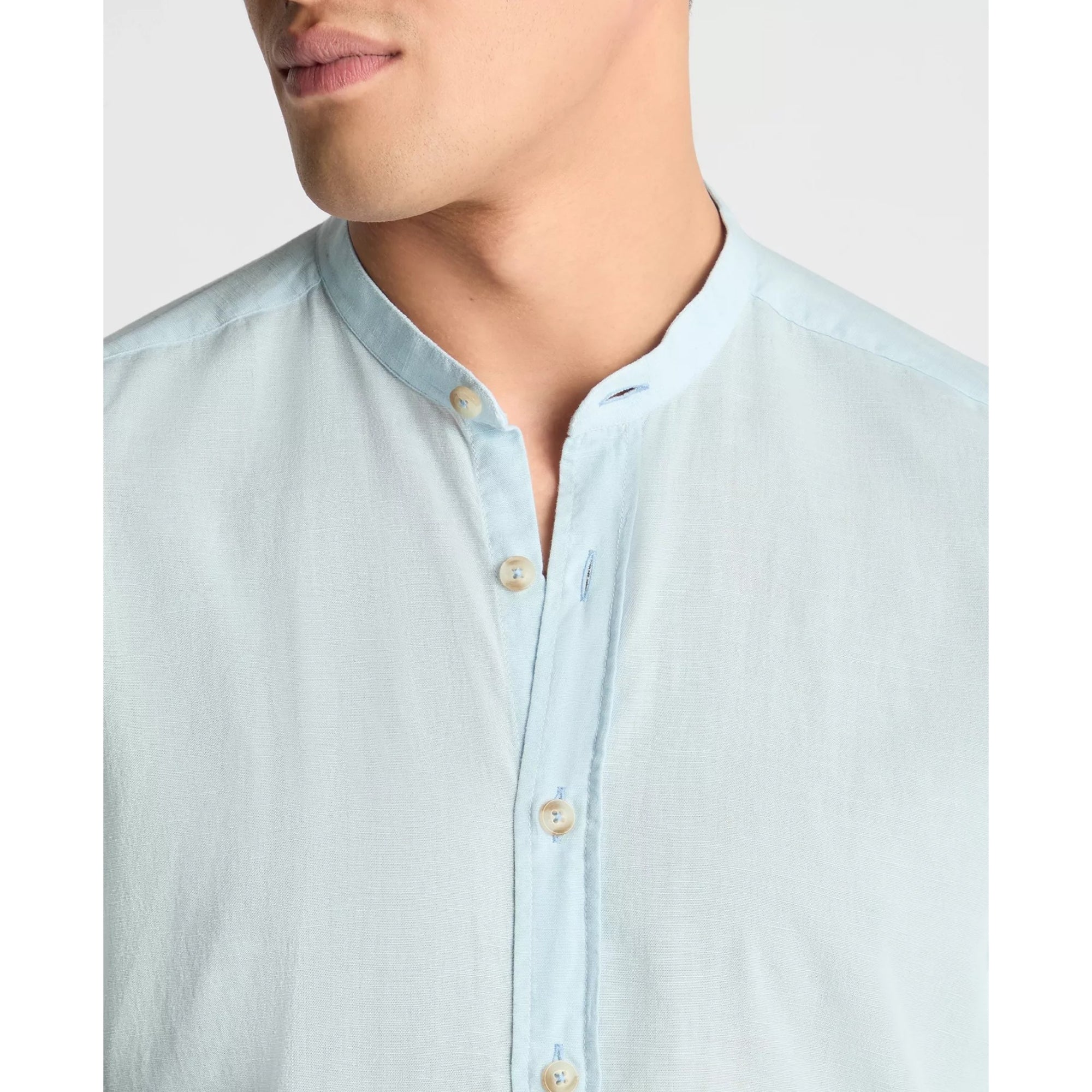 Light blue button-up shirt worn by a person on a plain background