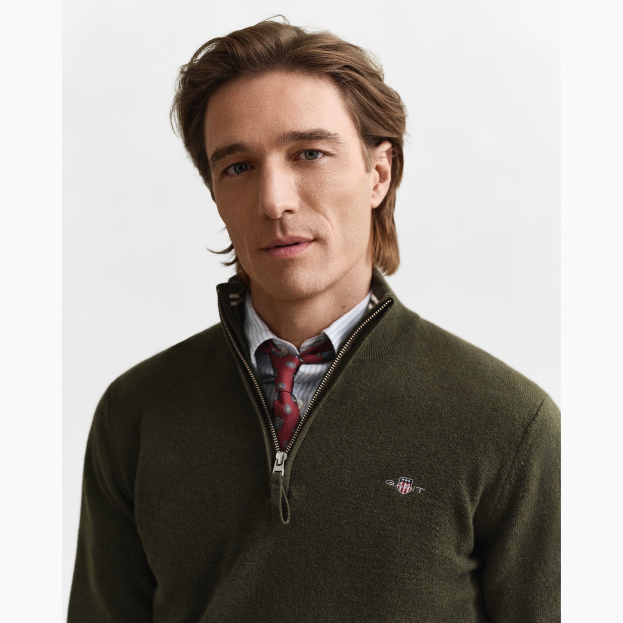 Man wearing a green sweater with a visible GANT logo 