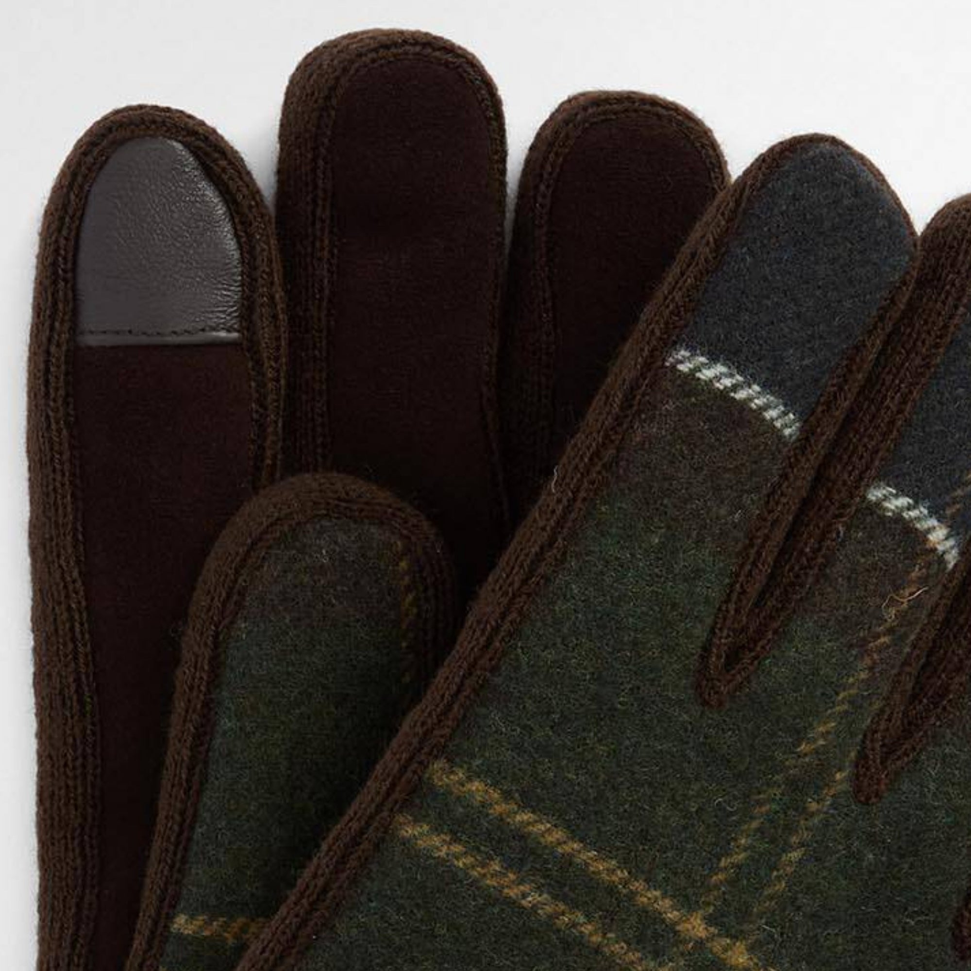 Pair of dark green gloves with plaid pattern on a white background