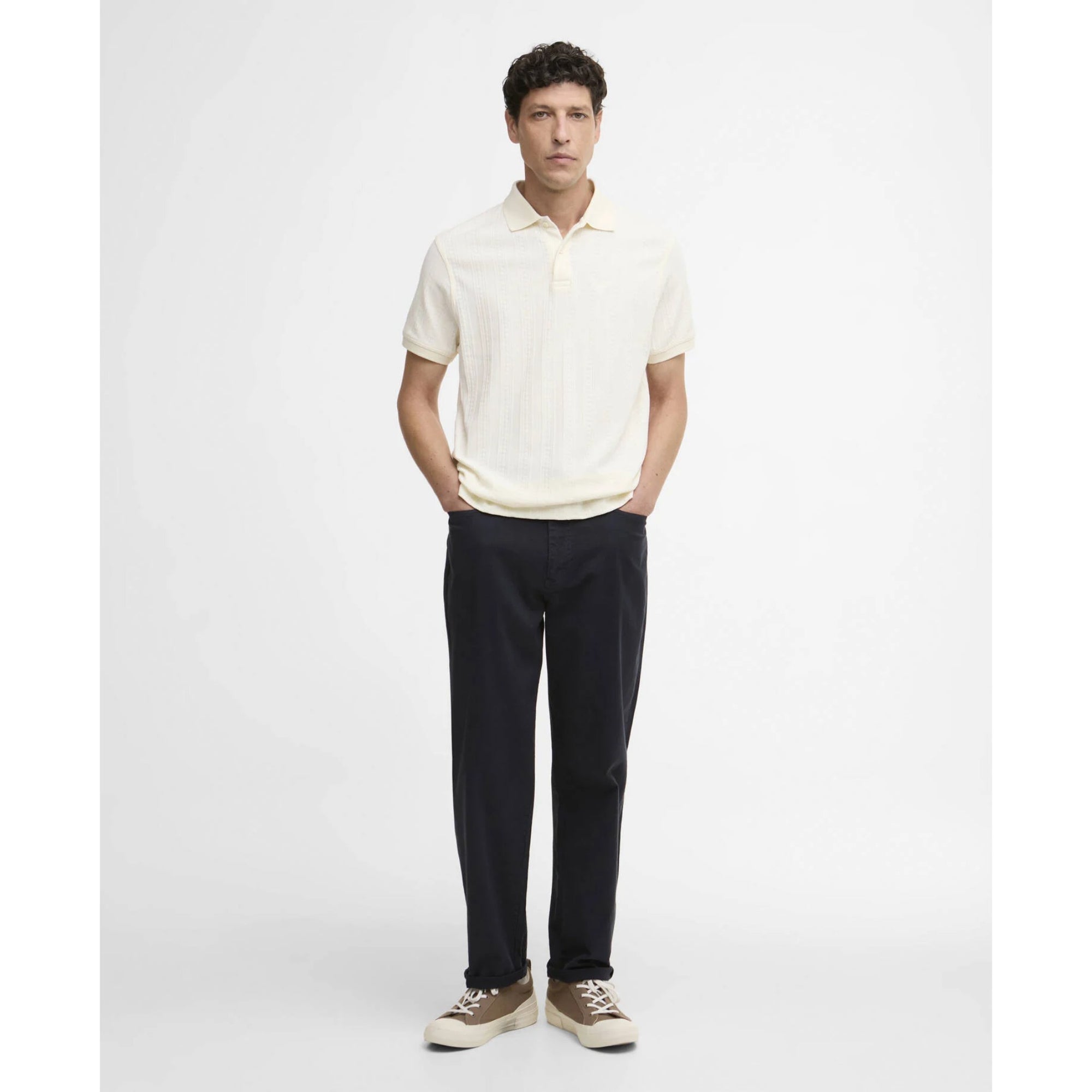 Man wearing a white polo shirt and black pants on a white background