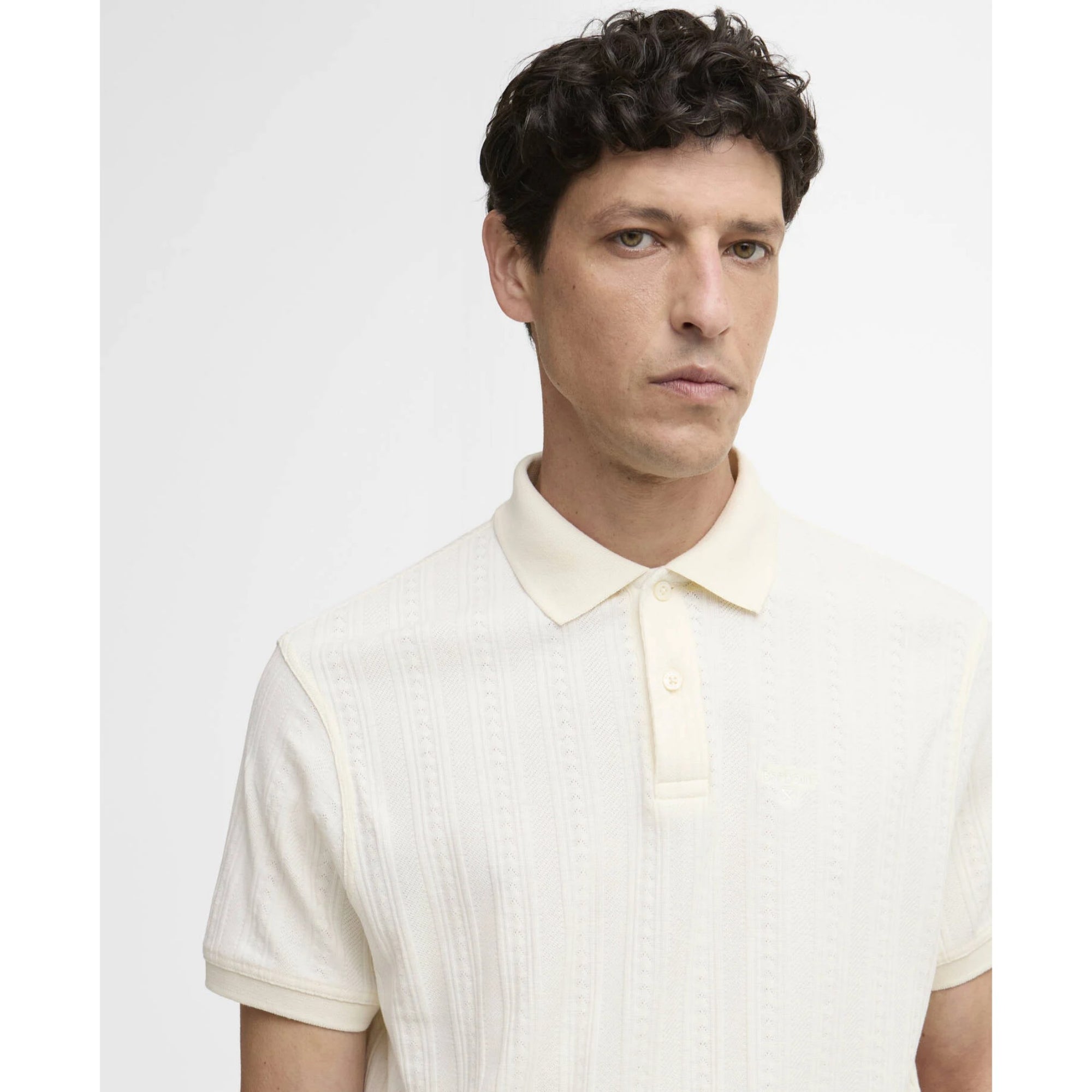 Man wearing a light-colored polo shirt against a plain background