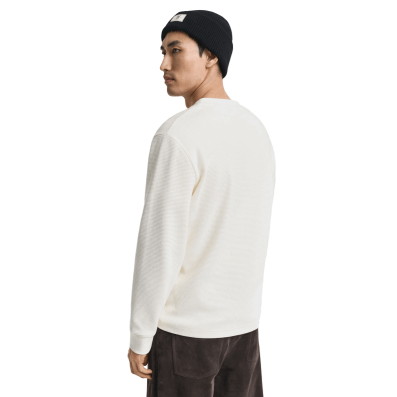 Person wearing a white sweatshirt and black beanie on a plain background
