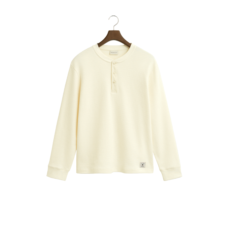 Light cream long-sleeve t-shirt on a hanger against a light gray background