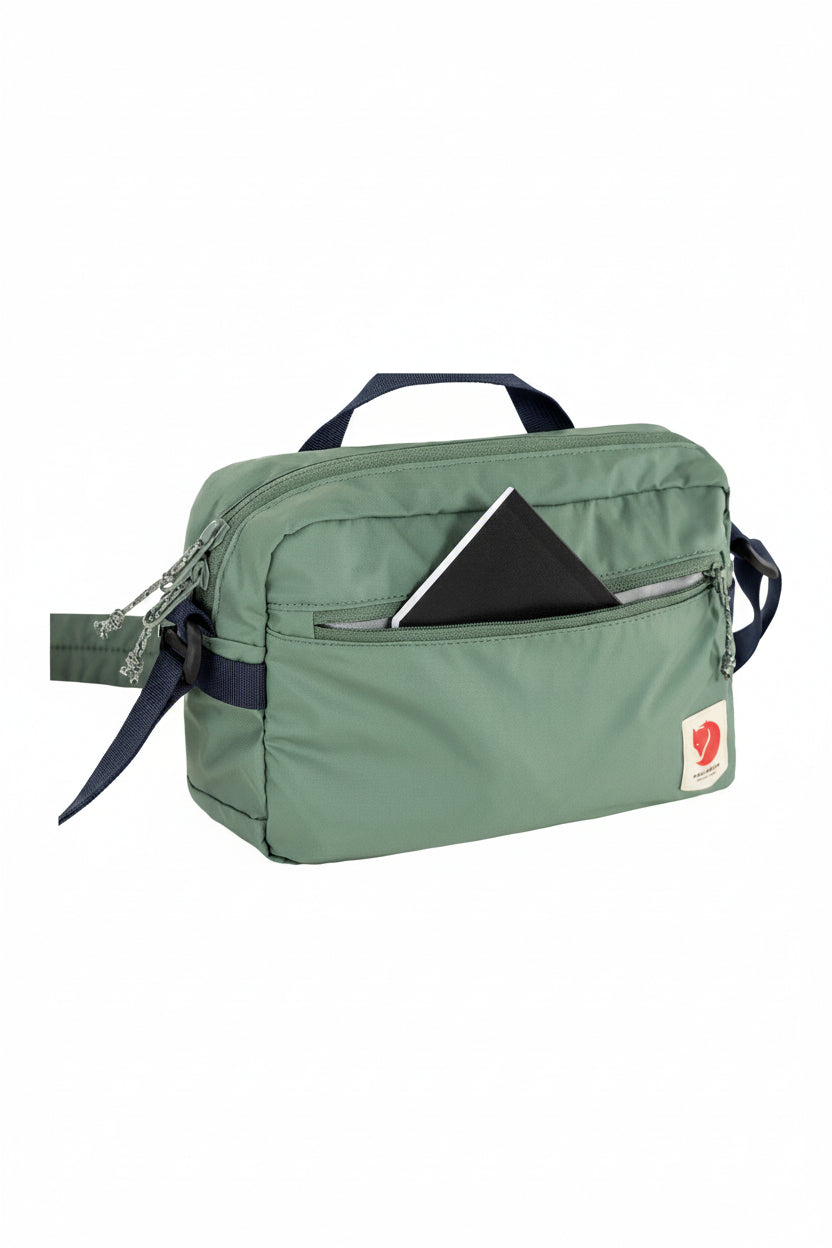 Green travel bag with a visible brand logo on a white background