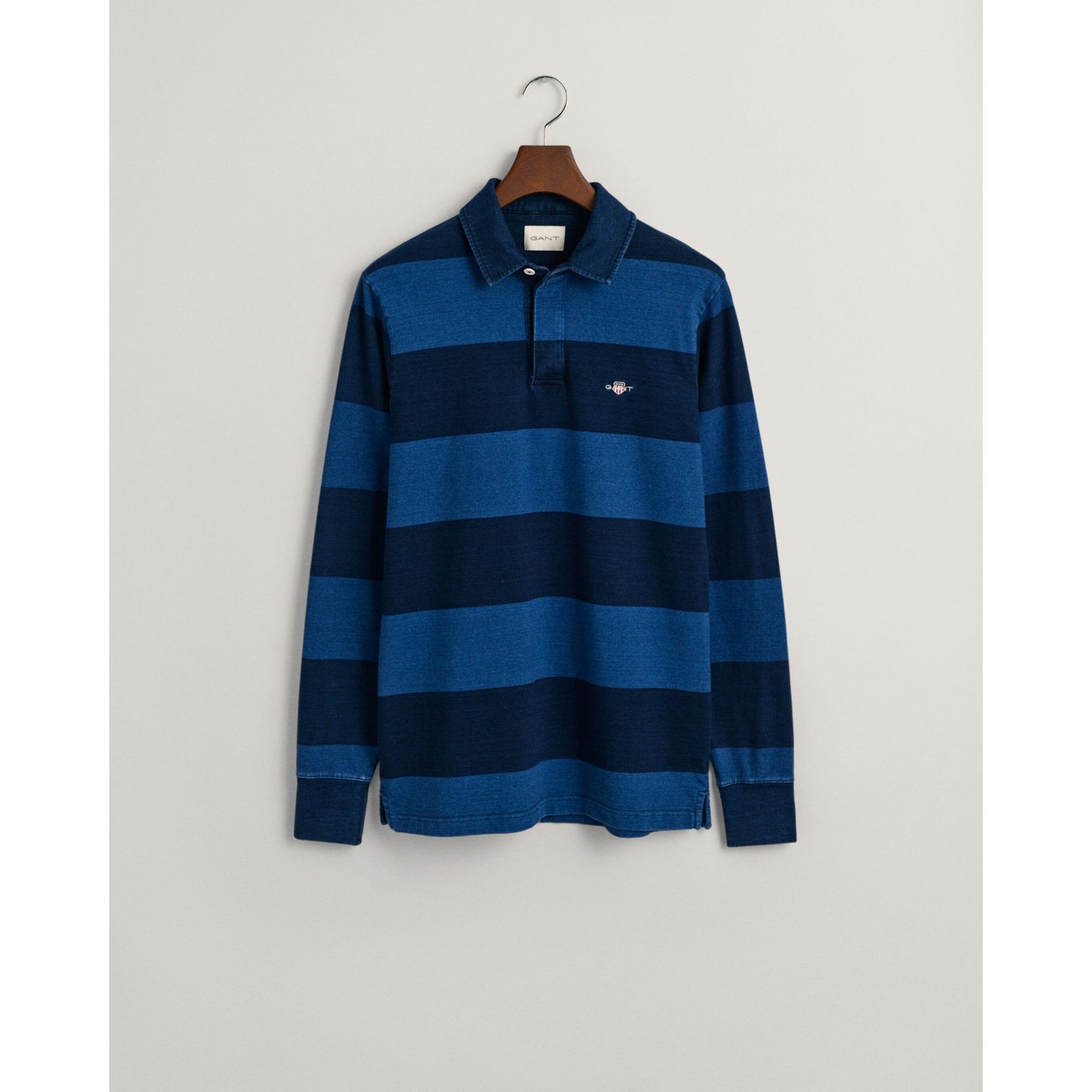 Blue and navy striped long-sleeve polo shirt on a hanger against a light gray background