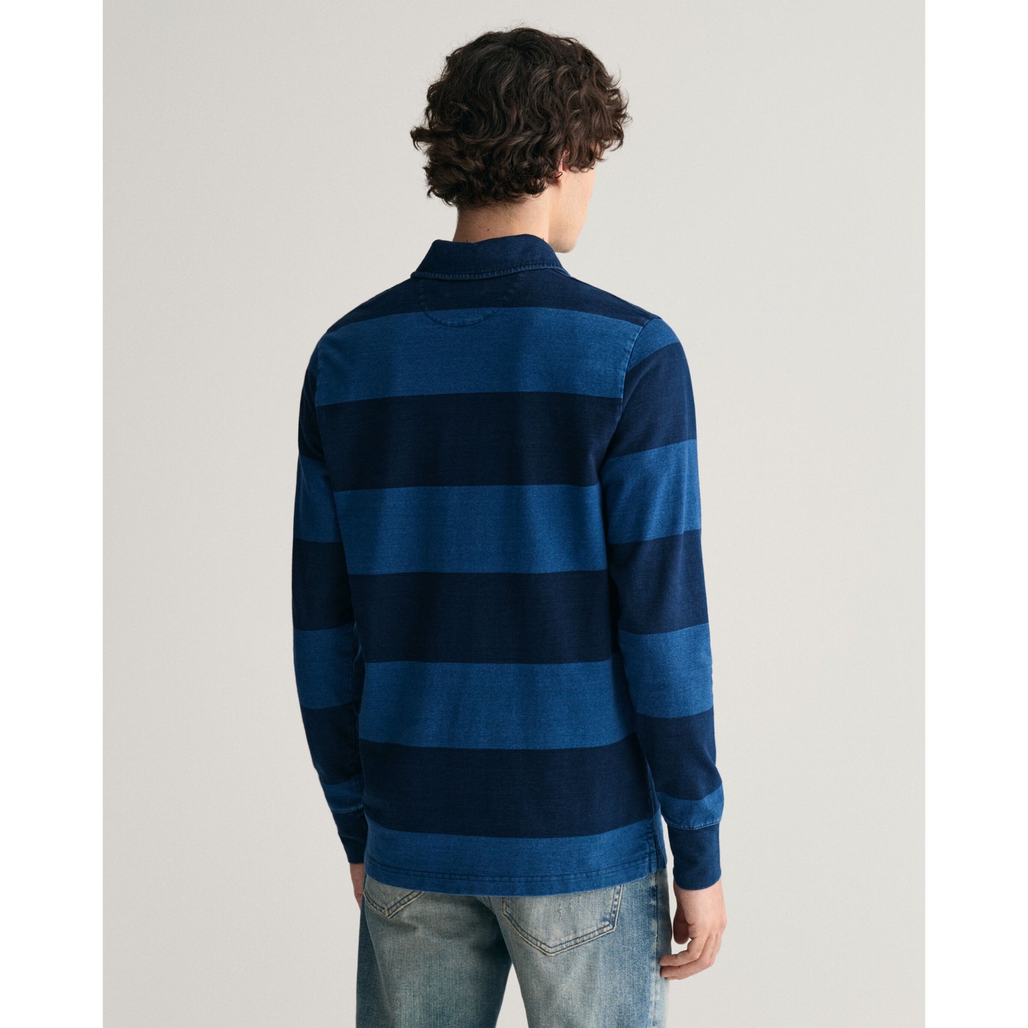 Person wearing a blue and navy striped shirt on a light gray background