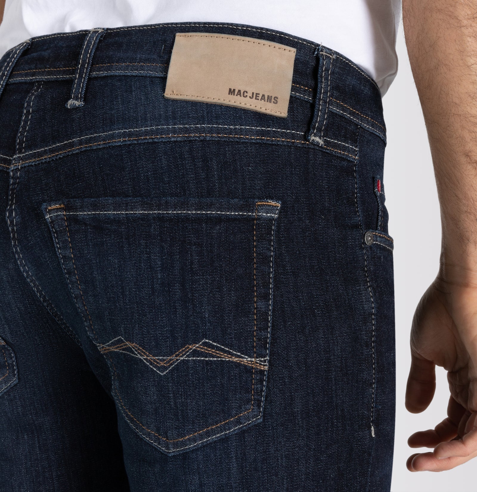 Dark blue jeans with a visible brand label on a plain background