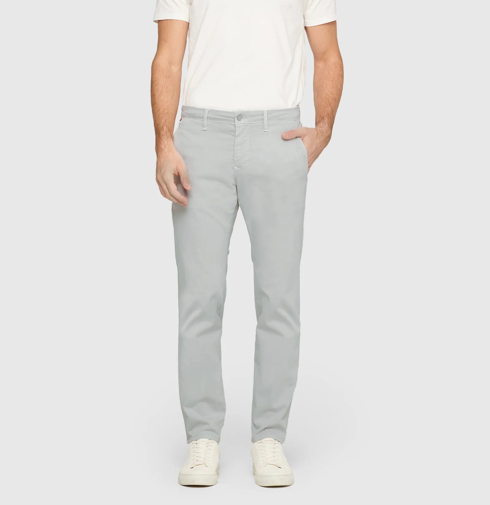 Person wearing light gray pants and a white shirt on a plain background