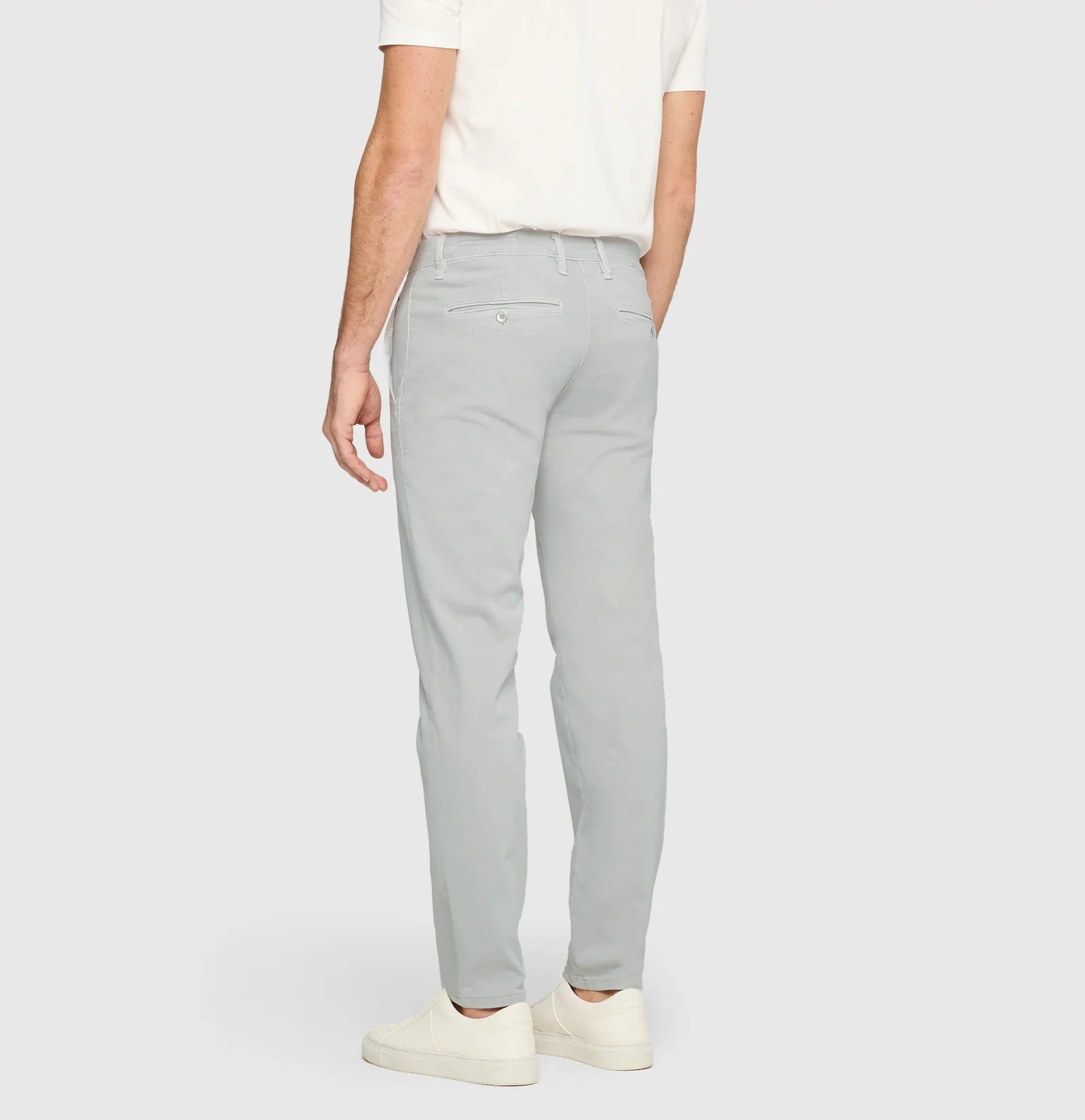 Person wearing light gray pants on a white background