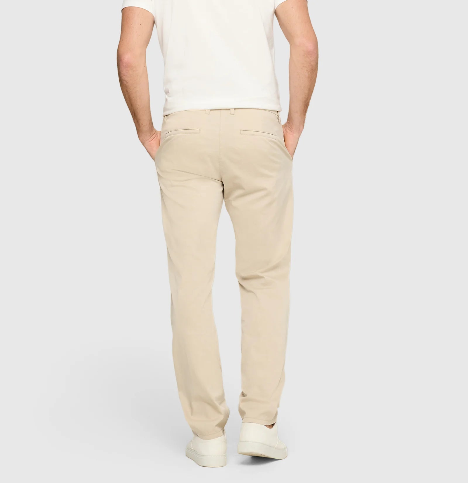 Person wearing beige pants on a white background