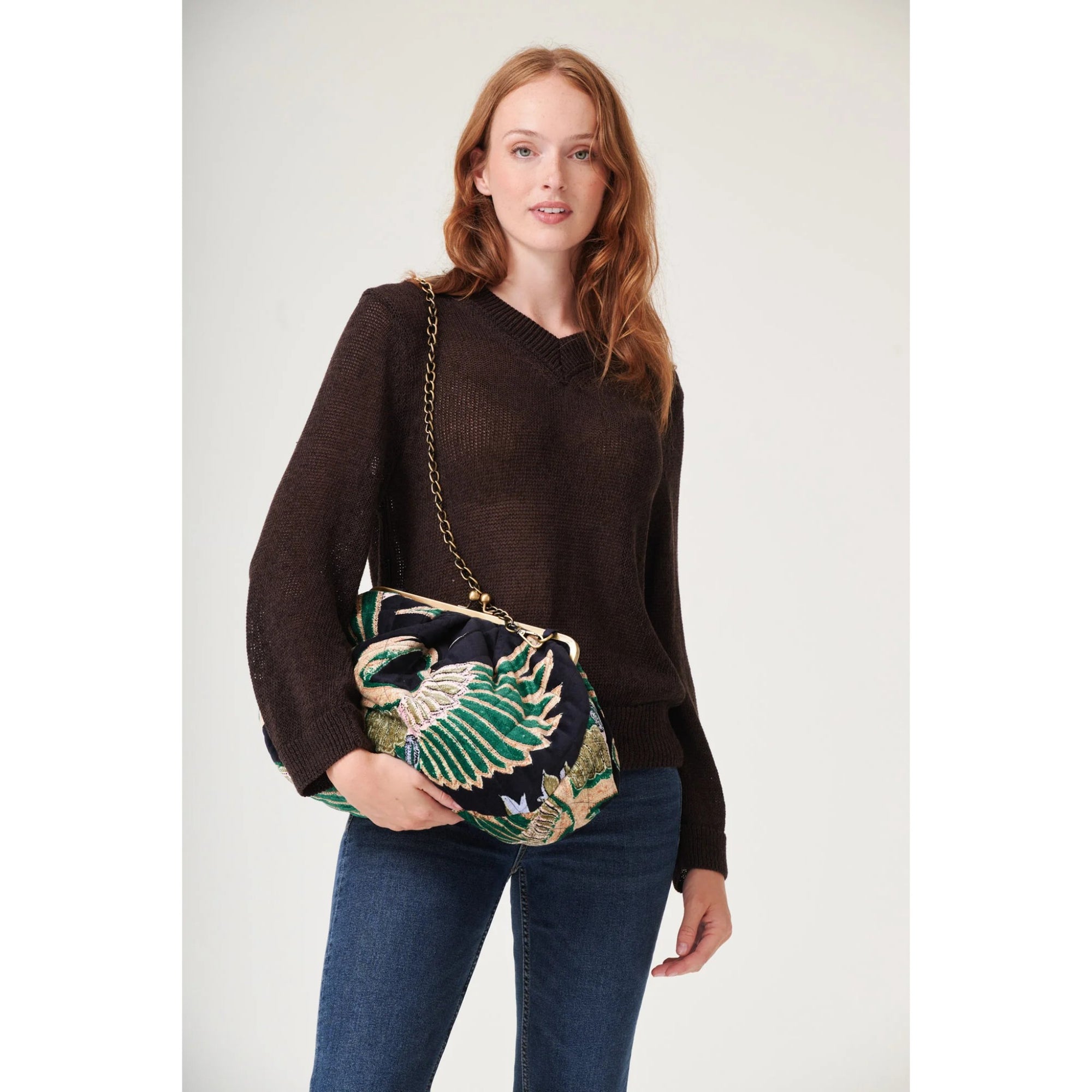 Woman holding a decorative handbag with a white background