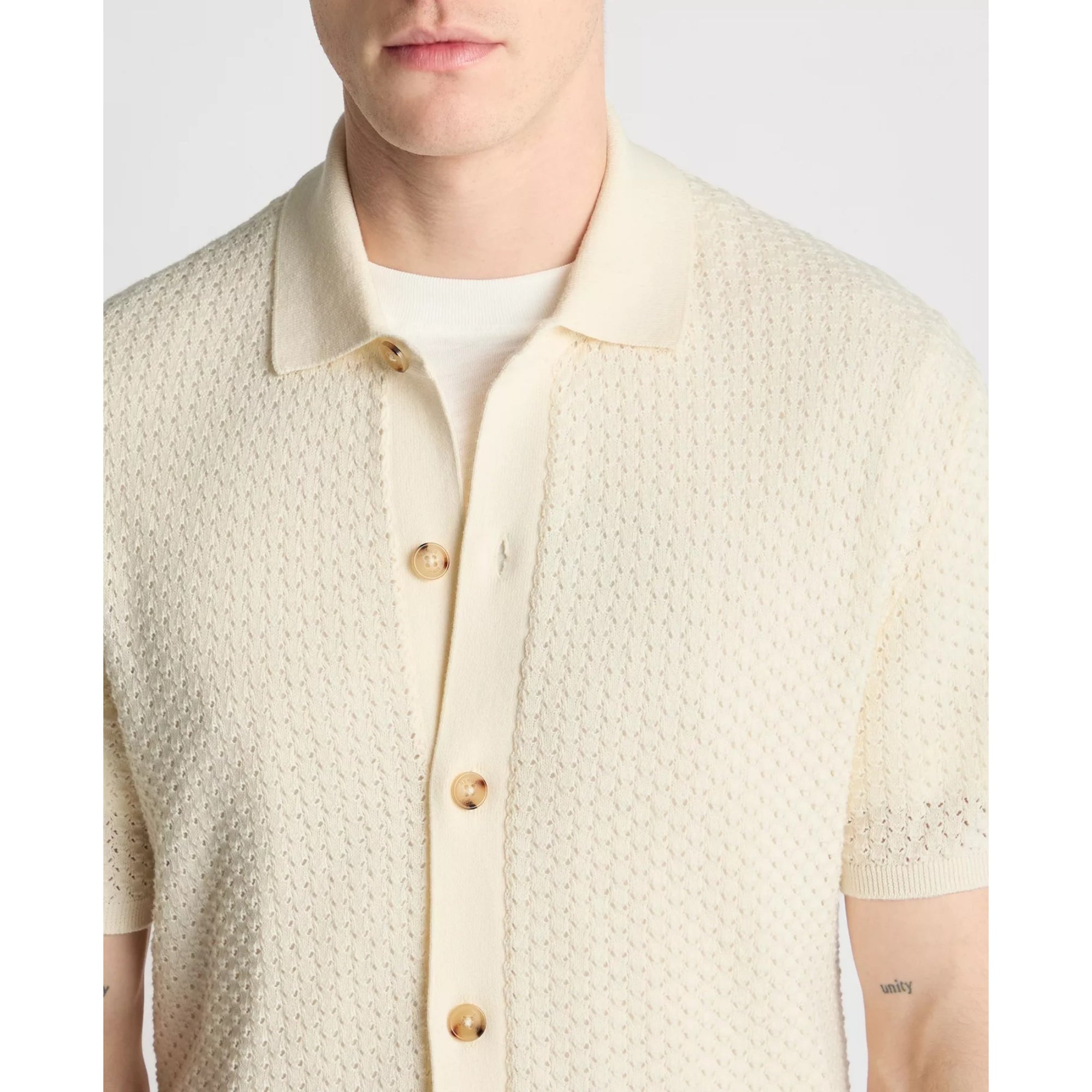 Man wearing a beige textured shirt with buttons on a light gray background