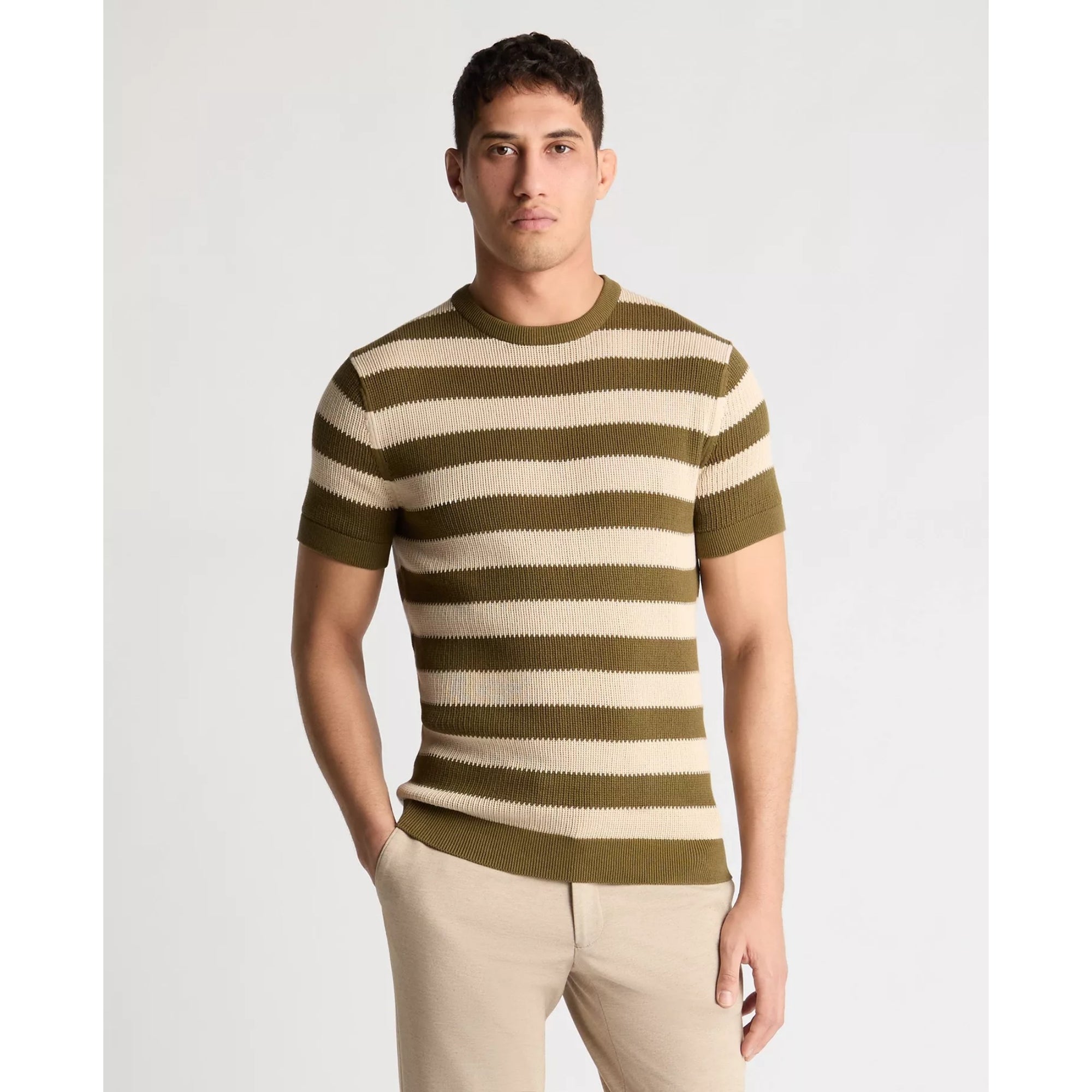 Man wearing a green and beige striped sweater on a light gray background