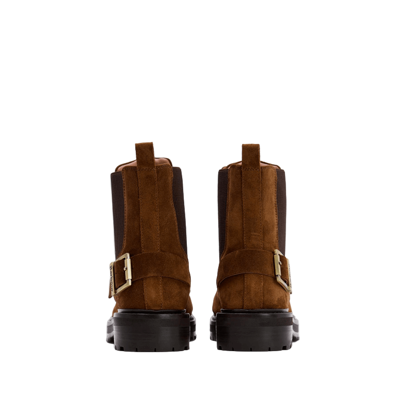 Pair of brown suede boots with buckles on a white background