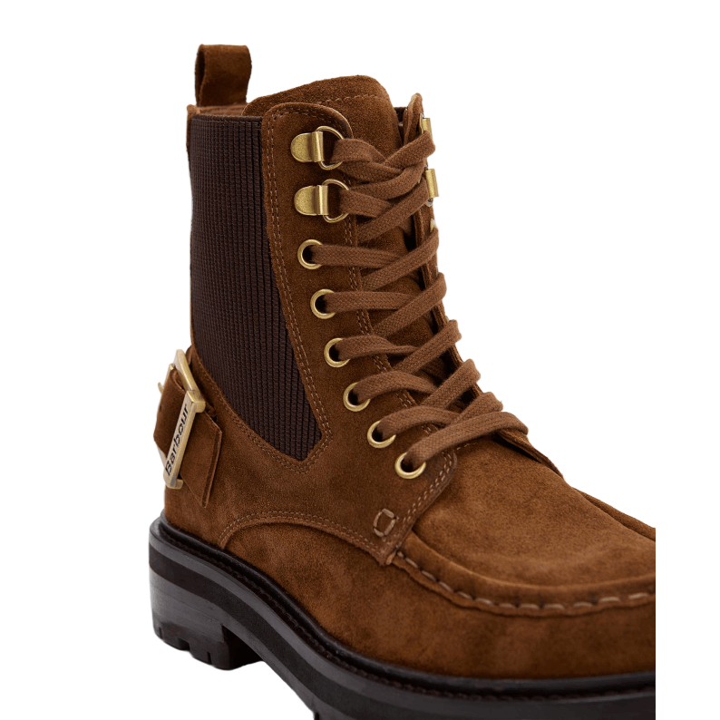 Brown suede boot with gold laces on a light gray background