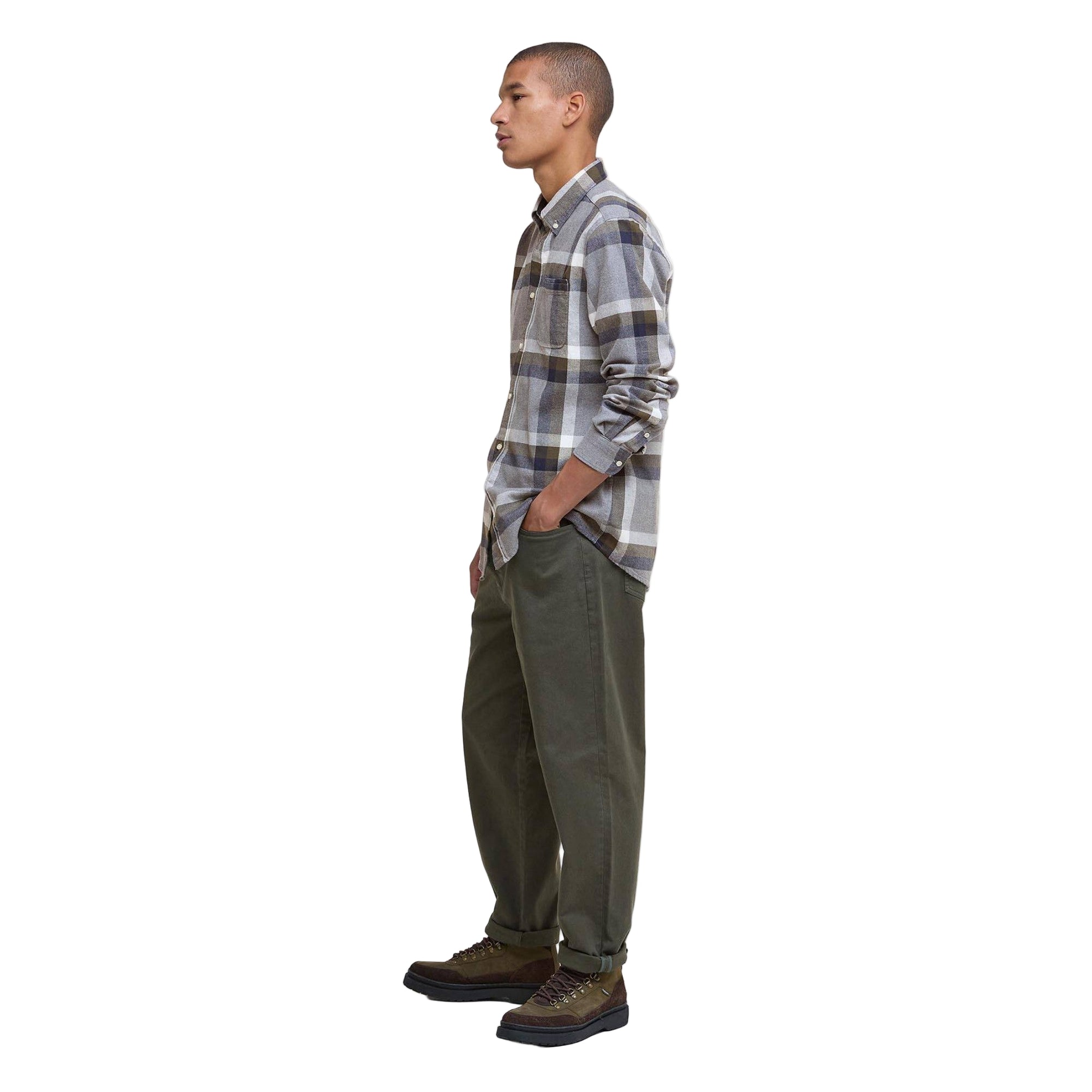 Man wearing a plaid shirt and green pants on a white background
