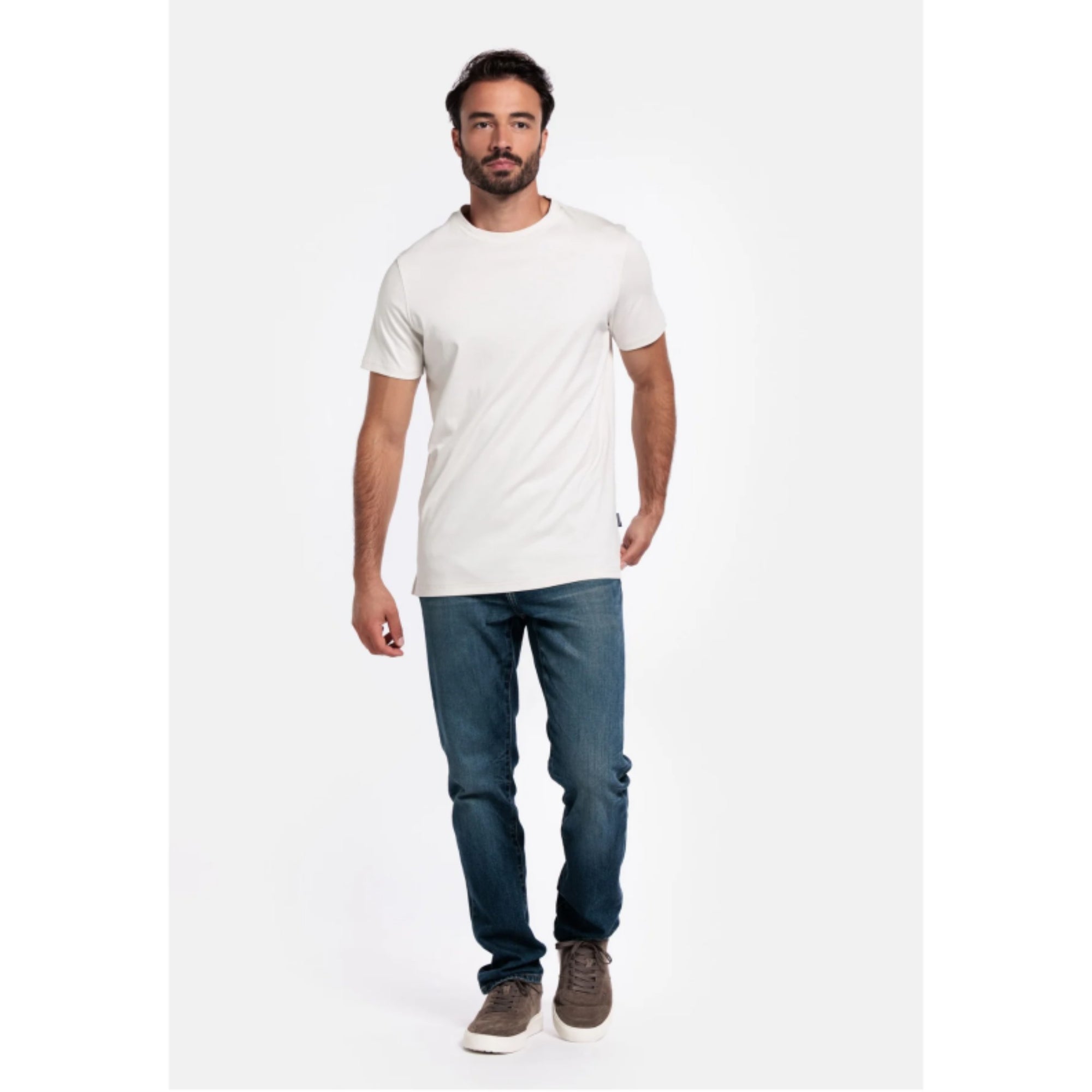 Man wearing a white Giordano t-shirt and blue jeans on a white background