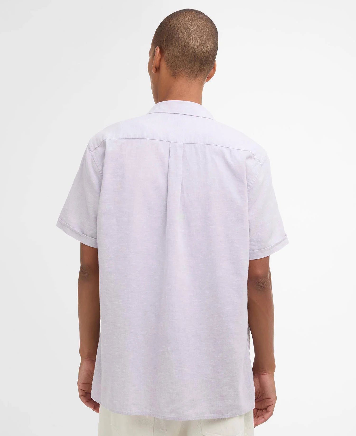 Person wearing a light-colored short-sleeve shirt on a white background