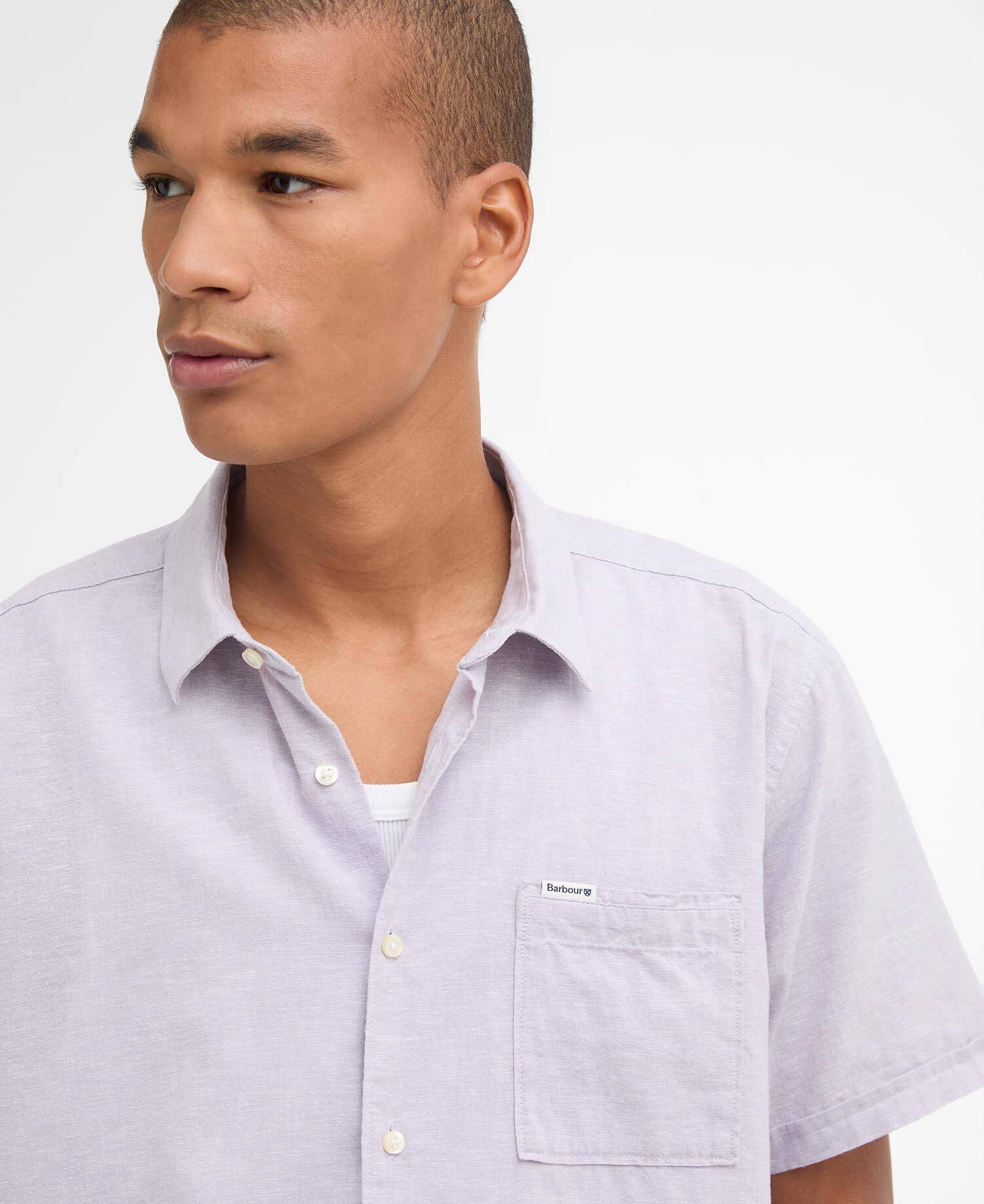 Man wearing a light purple short-sleeve shirt with a collar on a white background