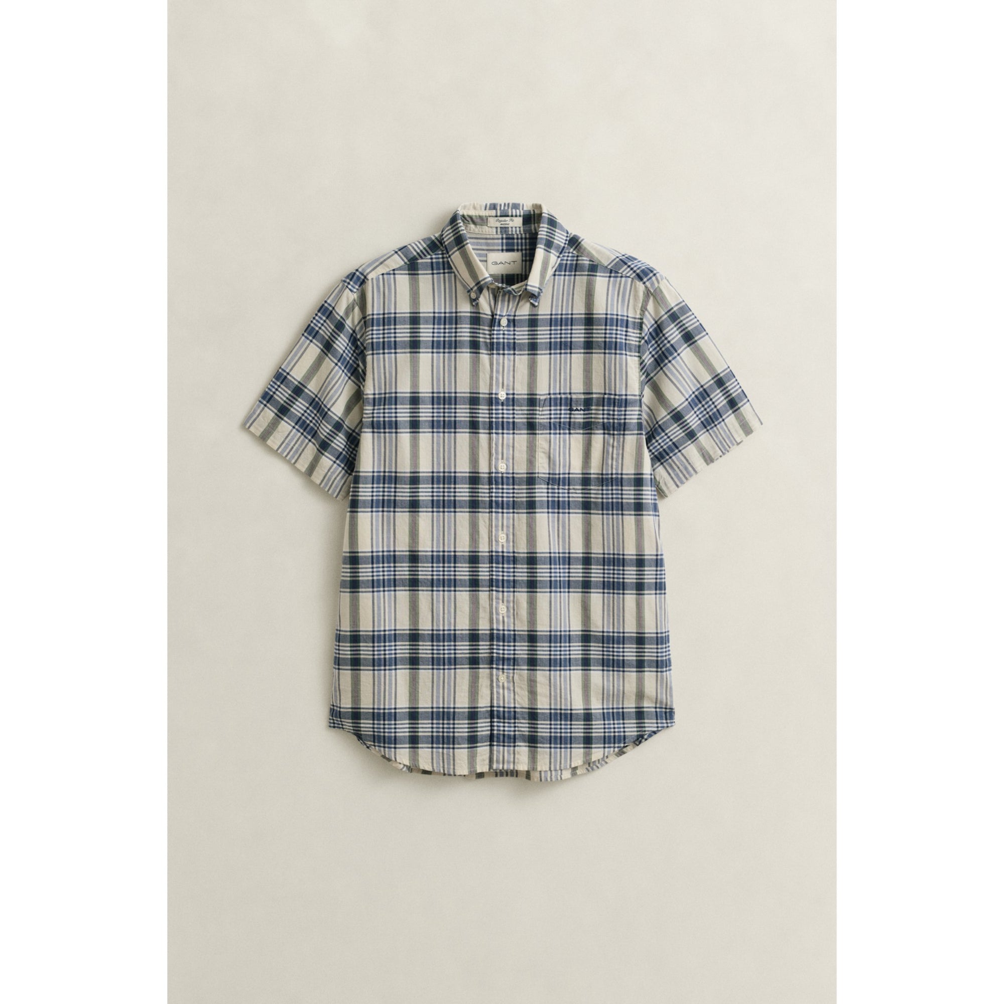 Plaid short-sleeve shirt on a light beige background