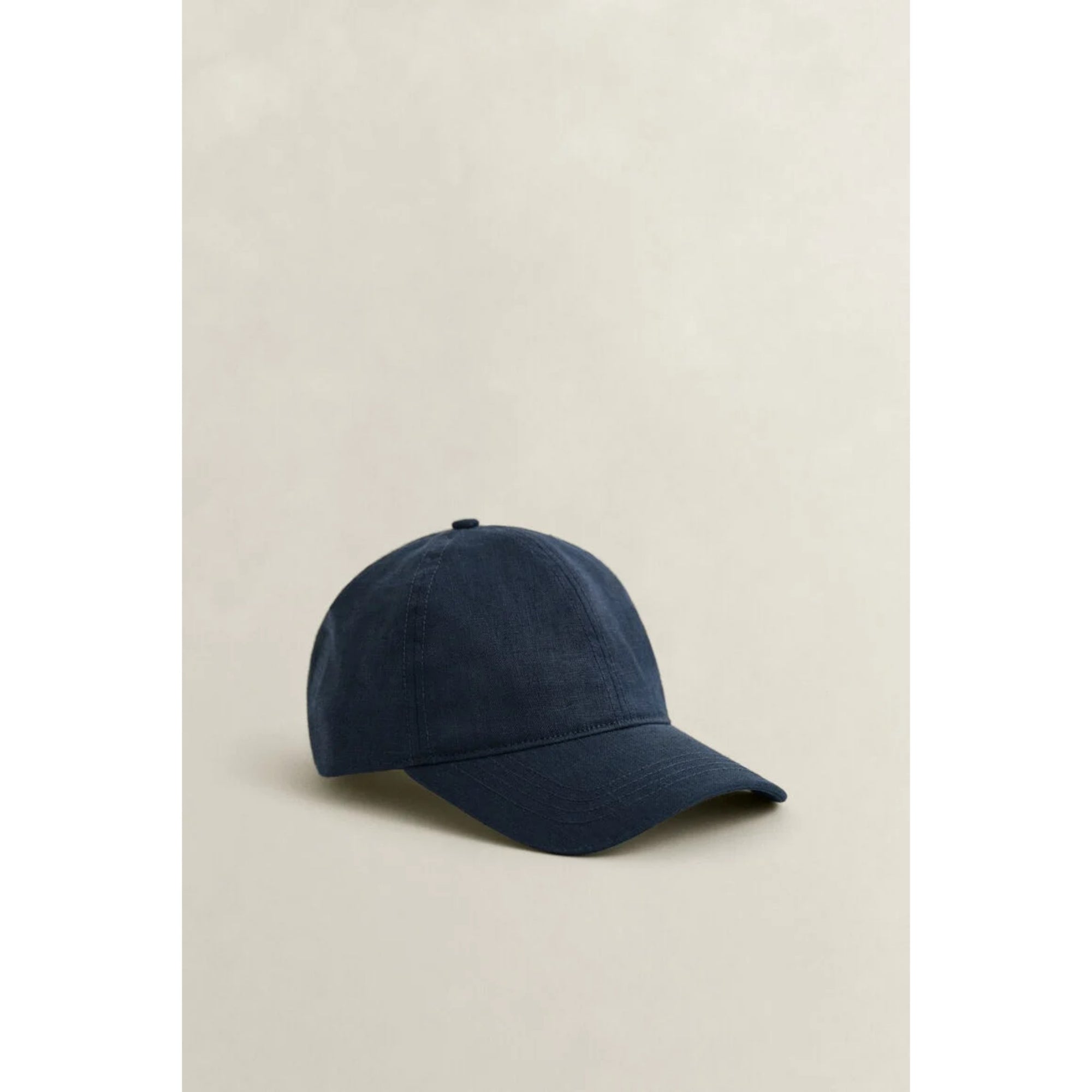 Navy blue baseball cap on a beige background