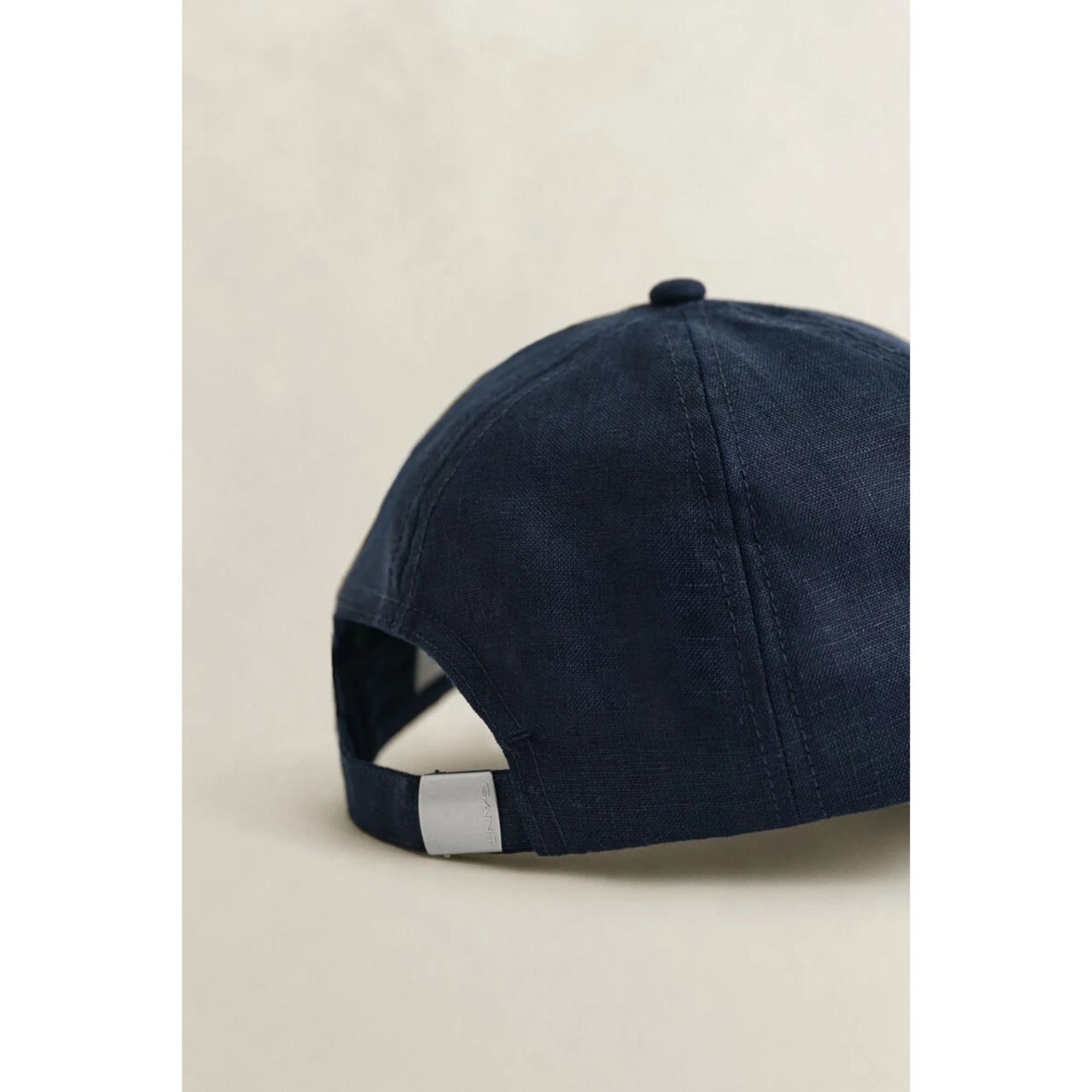 Navy blue baseball cap on a beige background