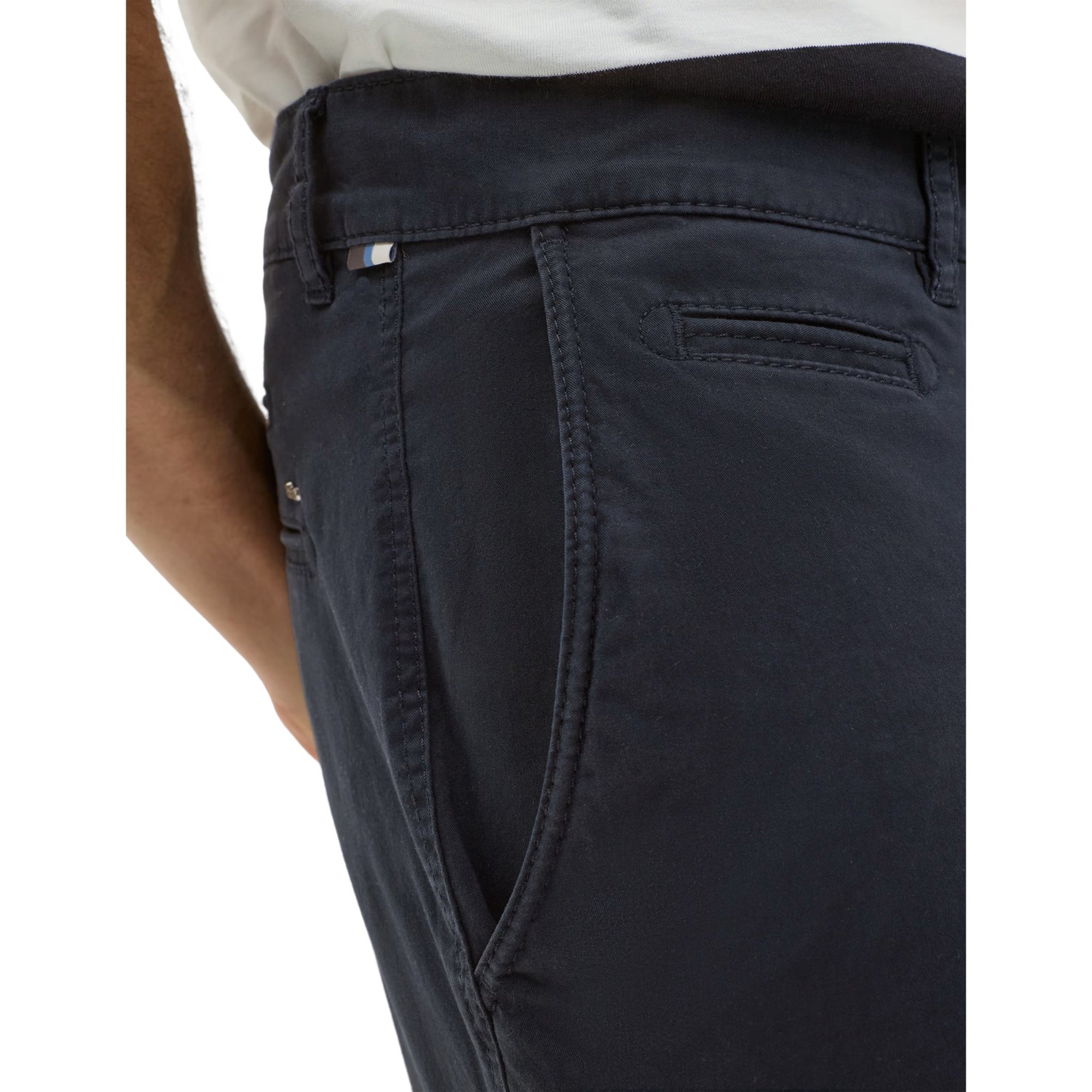 Close-up of dark pants with a visible brand logo on a white background