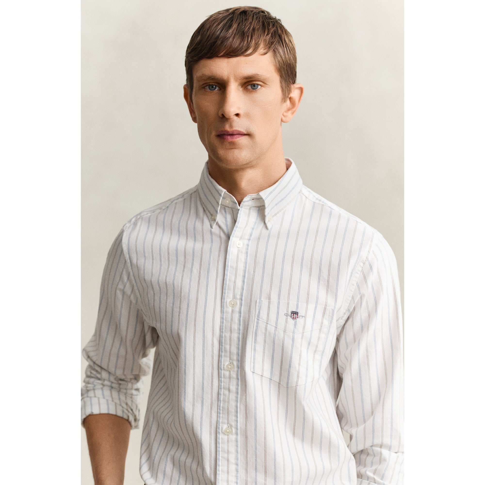 Man wearing a white striped shirt against a plain background