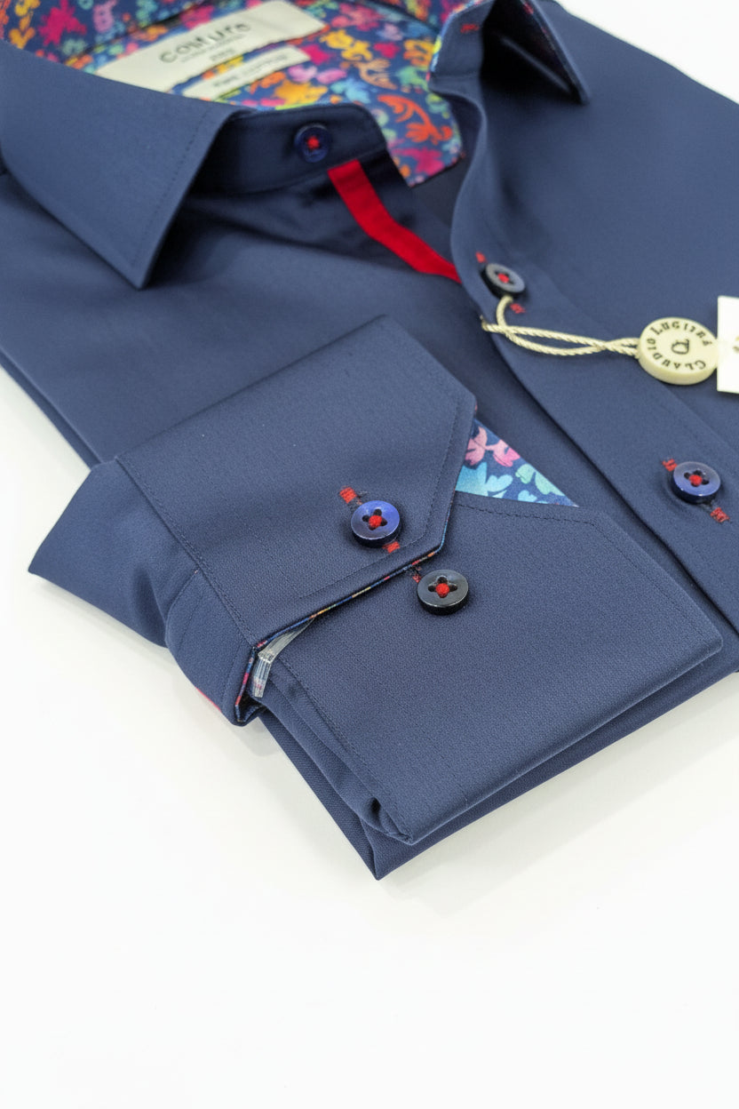 Blue dress shirt with colorful inner lining and buttons on a wooden surface