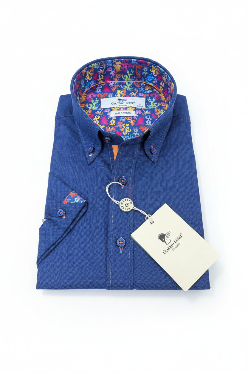 Folded blue shirt with colorful patterned collar featuring a multi coloured trim detail and rainbow 