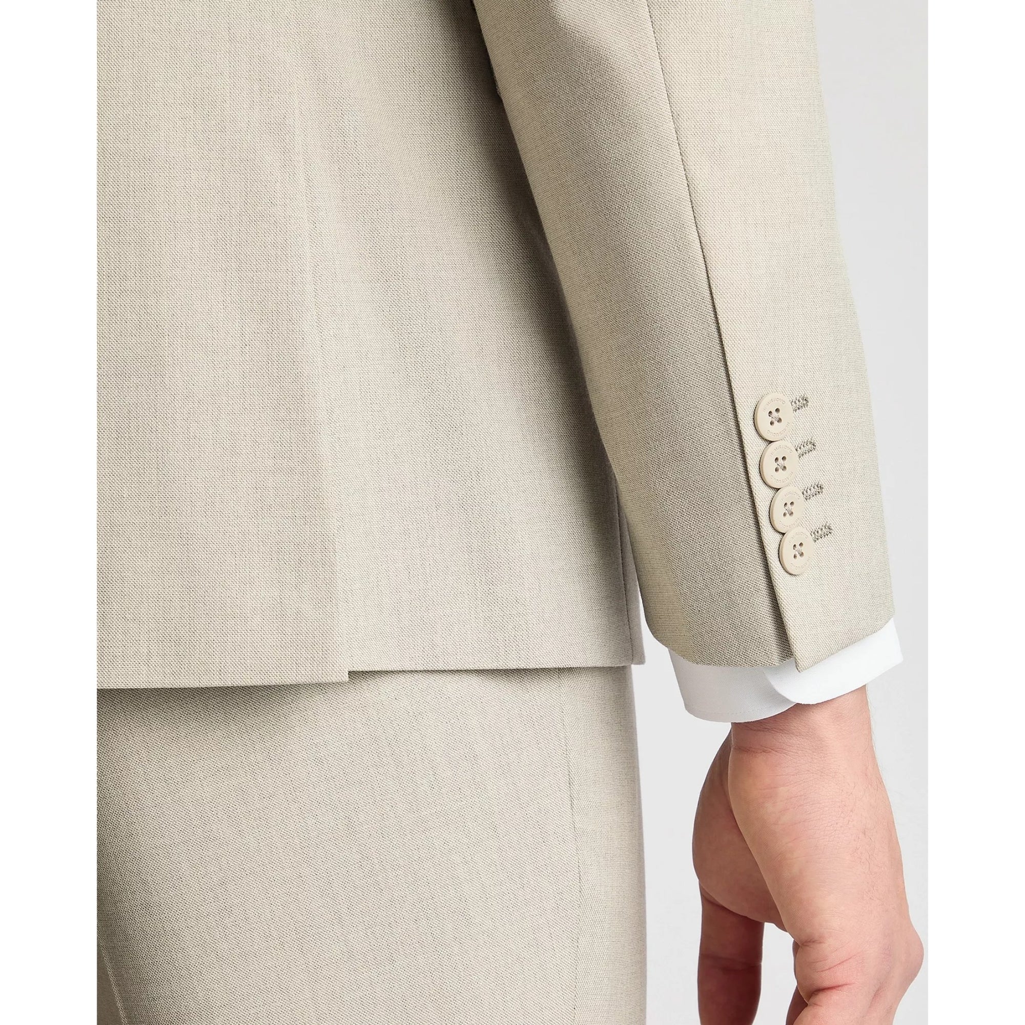 Close-up of a beige suit jacket with buttons on a white background