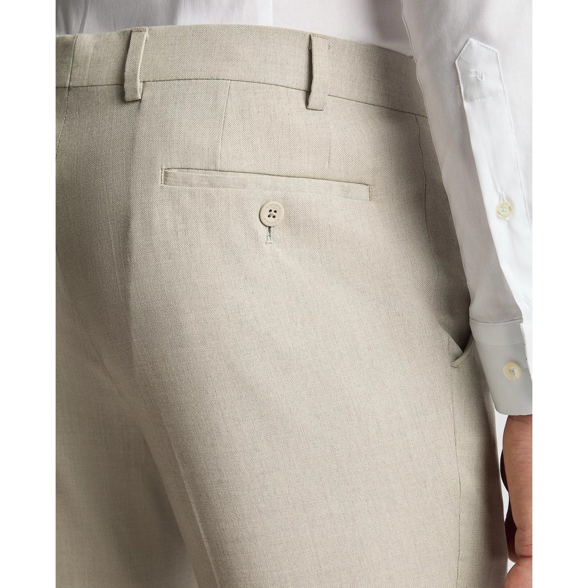 Close-up of beige pants with a white shirt on a light gray background